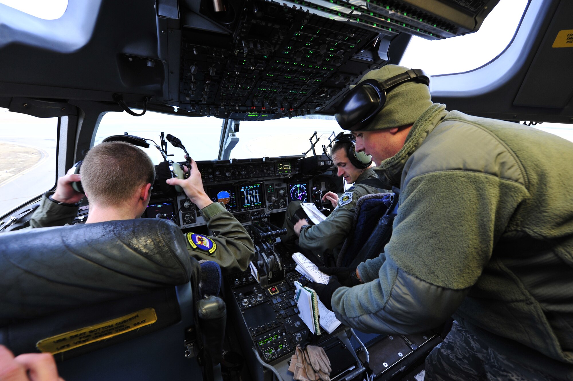 Capt. David Gaulin, Contingency Response Element director of operations from the 817th Contingency Response Group, 621st Contingency Response Wing, Joint Base McGuire-Dix-Lakehurst, N.J. speaks wit aircrew aboard a C-17 Globemaster III during a field training exercise at the Lakehurst Naval Air Engineering Station Dec. 8. The CRE was practicing its ability to establish air bases in austere environments. (U.S. Air Force photo by Tech. Sgt. Parker Gyokeres/released)