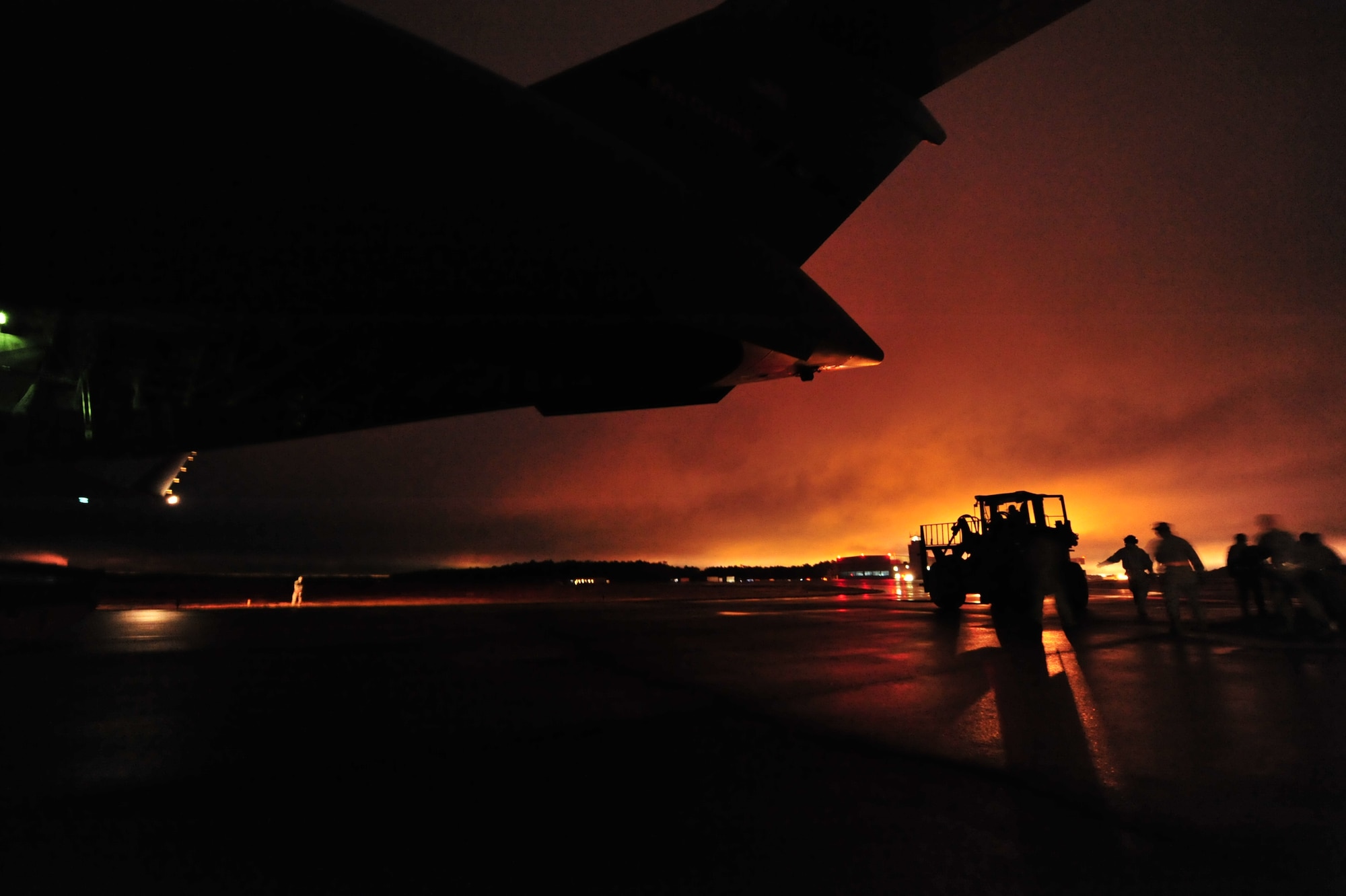 Airmen from the 817th Contingency Response Group, 621st Contingency Response Wing, Joint Base McGuire-Dix-Lakehurst, N.J. position a forklift to unload cargo from a C-17 Globemaster III during a night field training exercise at the Lakehurst Naval Air Engineering Station Dec. 6. Airmen in the CRW are expected to deploy worldwide at any time and train constantly in scenarios that recreate the conflicts and humanitarian crises they may be called into to support. (U.S. Air Force photo by Tech. Sgt. Parker Gyokeres/released)