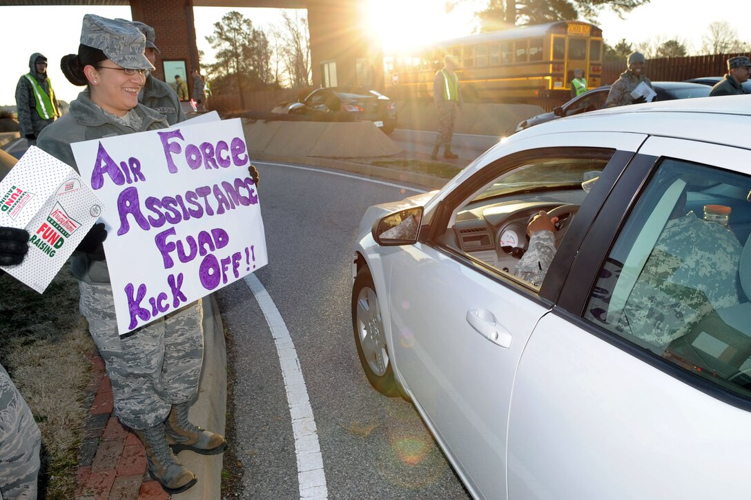 U.S. Air Force Senior Airman Imelda Allen, 633rd Medical Group, holds a sign during the Air Force Assistance Fund doughnut fundraiser at the Langley Air Force Base West Gate, Feb. 7, 2012. The AFAF helps provide relief to both officer and enlisted active duty Air Force members and retirees who have financial troubles and need aide. (U.S. Air Force photo by Staff Sgt. Jeff Nevison/Released)