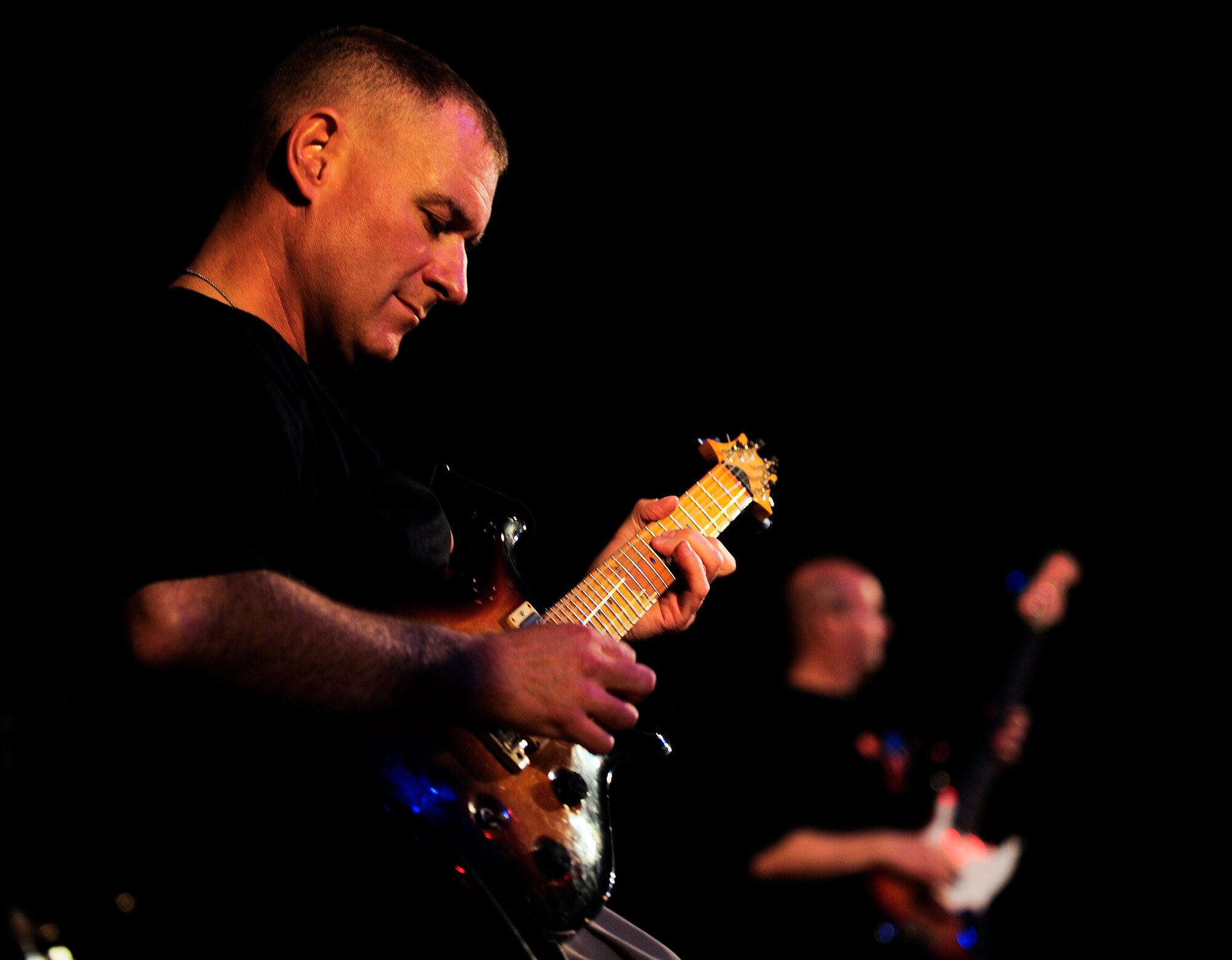 Master Sgt. Gary Noel plays electric guitar with the U.S. Air Forces Central Band Afterburner Feb. 7, 2012, during a concert at the Russian Drama Theater in Bishkek, Kyrgyzstan. The Russian Drama Theater was Afterburner's last concert during their nine-day tour in Kyrgyzstan. Noel is deployed from Hanscom Air Force Base, Mass. (U.S. Air Force Photo/Staff Sgt. Angela Ruiz)