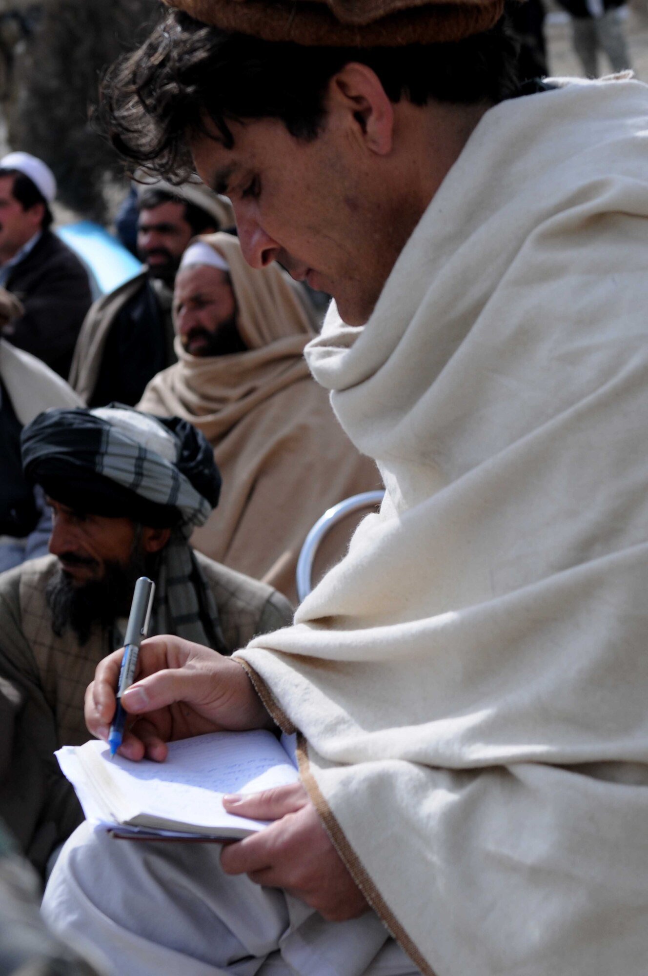 PAKTYA PROVINCE, Afghanistan— A Chamkani District resident takes notes during a government outreach mission in Paktya Province, Afghanistan, Feb 1. Outreach missions link the community to their government by providing a venue in which villagers are invited to openly ask questions and receive direct answers. (U.S. Air Force photo by 1st Lt Cammie Quinn, Paktya Provincial Reconstruction Team Public Affairs) 