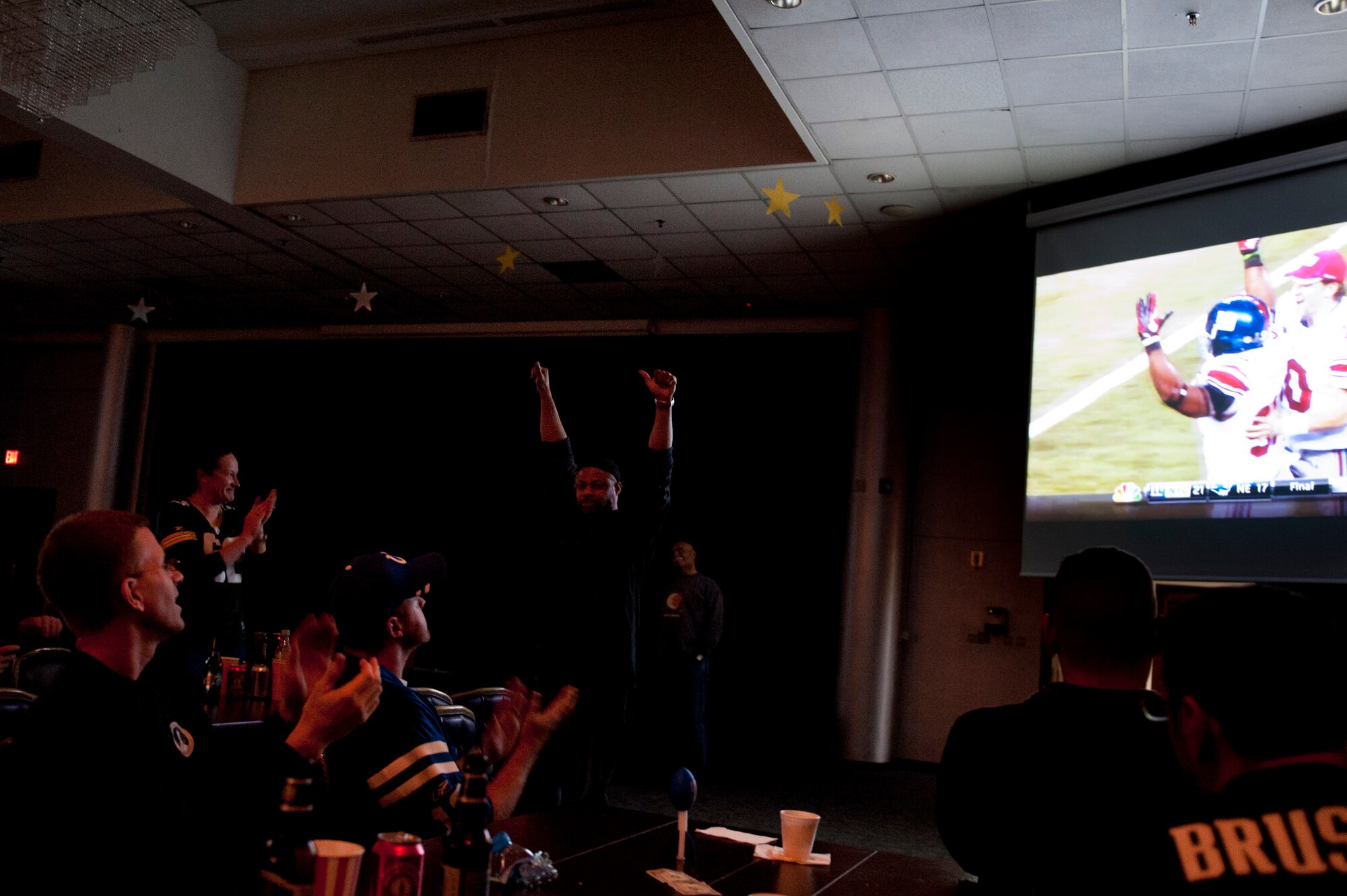 Fans cheer while watching the New York Giants defeat the New England Patriots during the Wing Super Bowl XLVI party Feb. 6, 2012, at the Club Complex ballroom at Incirlik Air Base, Turkey. The 39th Force Support Squadron-sponsored event featured a commercial contest that awarded $3,000 in wing funds to the winning unit. The 39th FSS won first and third place, winning $3,000 and $1,000, respectively; the 39th Maintenance Squadron won second, winning $2,000; and the individual category submission was from Nathan Kaw-Uh, who won a $100 voucher toward an Outdoor Recreation Connection trip. (U.S. Air Force photo by Tech. Sgt. Michael B. Keller/Released)