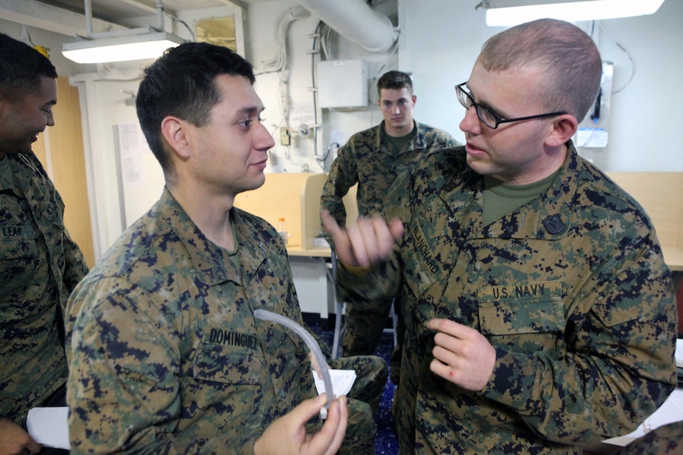 (Right) Seaman Scott Blanchard, a hospital corpsman, with Combat Logistic Battalion 24, 24th Marine Expeditionary Unit, teaches Lance Cpl. Ariel Dominguez, a motor transportation operator with CLB 24, 24th MEU, how to use a rubber hose to create a pathway for breathing during a Combat Life Savers Course Feb. 8. The 24th MEU is conducting their Certification Exercise (CERTEX) with Amphibious Squadron 8 scheduled Jan. 27 to Feb. 17, which includes a series of missions intended to evaluate and certify the unit for their upcoming deployment.