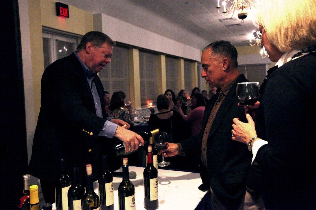 Bo Lindgren, the owner of Edward and Sophie Rollat winery (left) pours a glass of wine for Navy Capt. Milton D. Gianulis, the command chaplain with Marine Corps Base Camp Lejeune, Marine Corps Installations East during the Wine Tasting event held at the Paradise Point Officers’ Club aboard MCB Camp Lejeune, recently. Paradise Point Officers’ Club will be hosting their next wine tasting on March 8. ::r::::n::