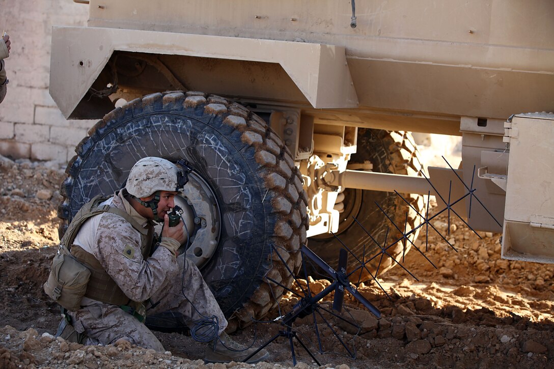 Sgt. Carlos Zuniga, 25, squad leader, from Popano Beach, Fla., checks in with his unit, a part of 2nd Battalion, 4th Marines. The Marines pushed through the city of Shah Karez and searched every building for explosives and drugs. Marines made use of their mobilized speed and night vision capability to disrupt and confuse enemy operations in the city of Shah Karez.