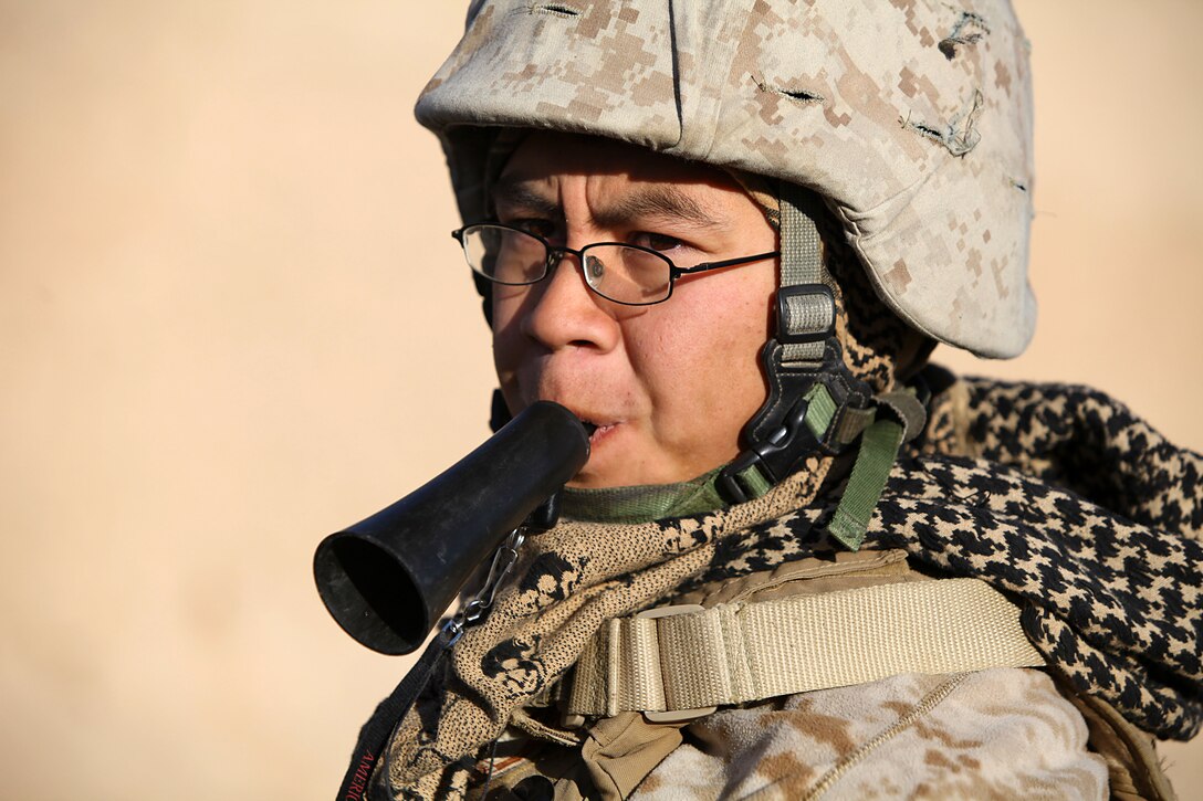 Cpl. Casey Chang, 21, dog handler, Detroit, Mich., uses a whistle to give commands to Tank. Tank is a military working dog that is trained to detect military and home made explosives. Chang completed a 6-week training course in order to understand the needs and training for his dog.