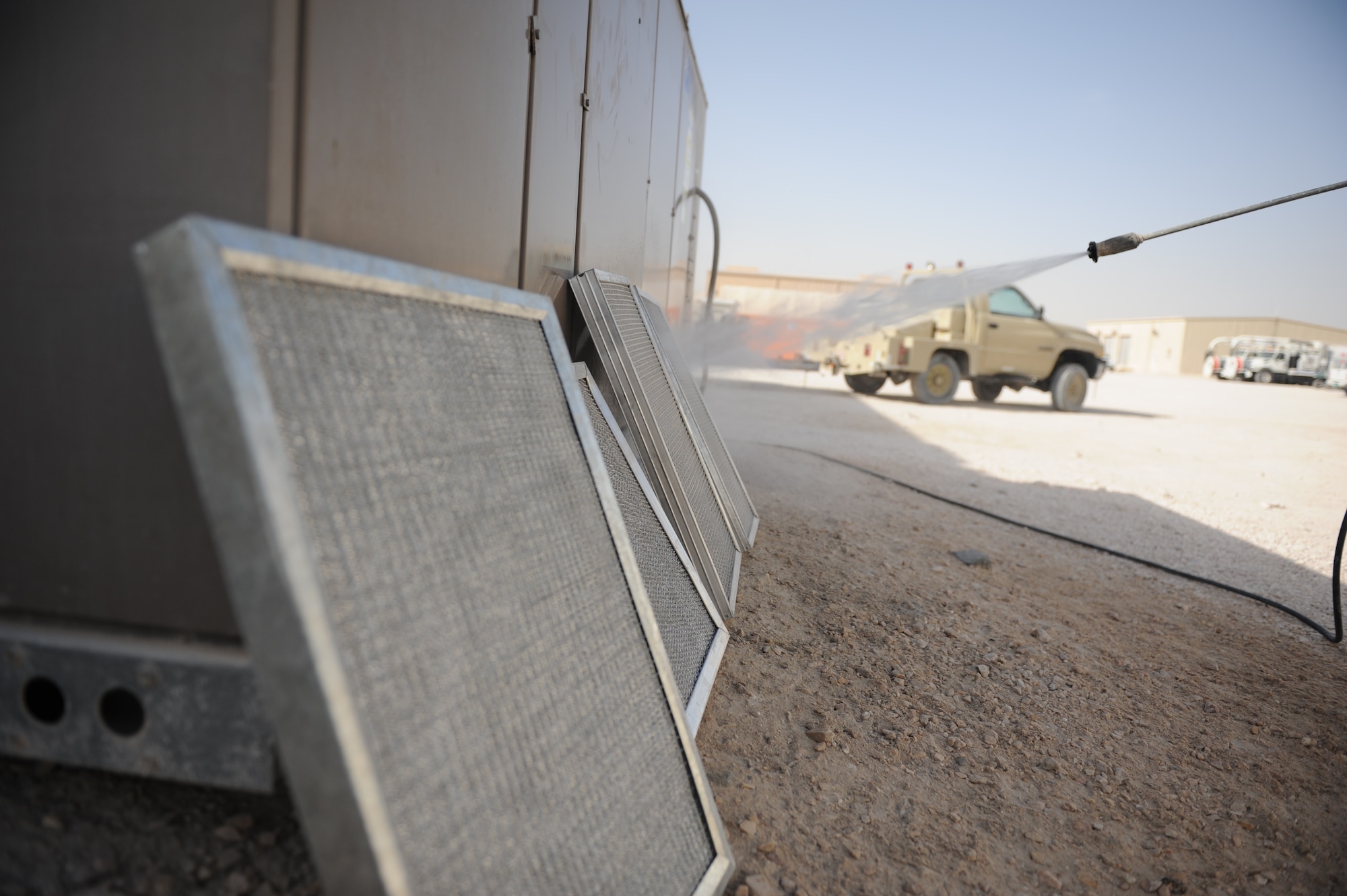 SOUTHWEST ASIA – Airman 1st Class David Yarolimek, 379th Expeditionary Civil Engineer Squadron heating, ventilation, and air conditioning technician and native of St. Augustine, Fla., sprays off air conditioning unit filters here Feb. 7, 2012. HVAC technicians clean the unit’s coils and filters, and check fan belts during a monthly inspection. (U.S. Air Force photo/Staff Sgt. Nathanael Callon)