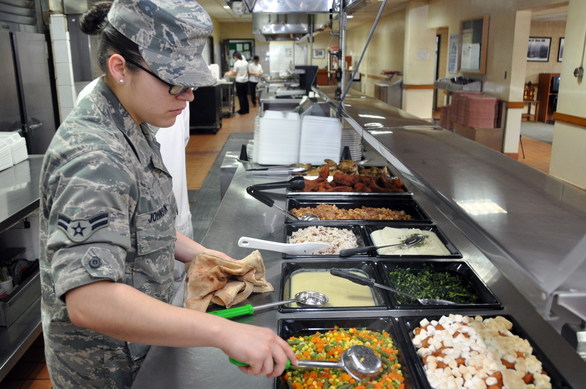 Airman 1st Class Mariah Johnson, 51st Force Support Squadron food apprentice, prepares the food service line for lunch at the Osan Air Base Pacific House Dining Facility, Jan. 28, 2012.  The Osan dining facilities serve more than 3,800 service members every day. (U.S. Air Force photo/Airman 1st Class Michael Battles)