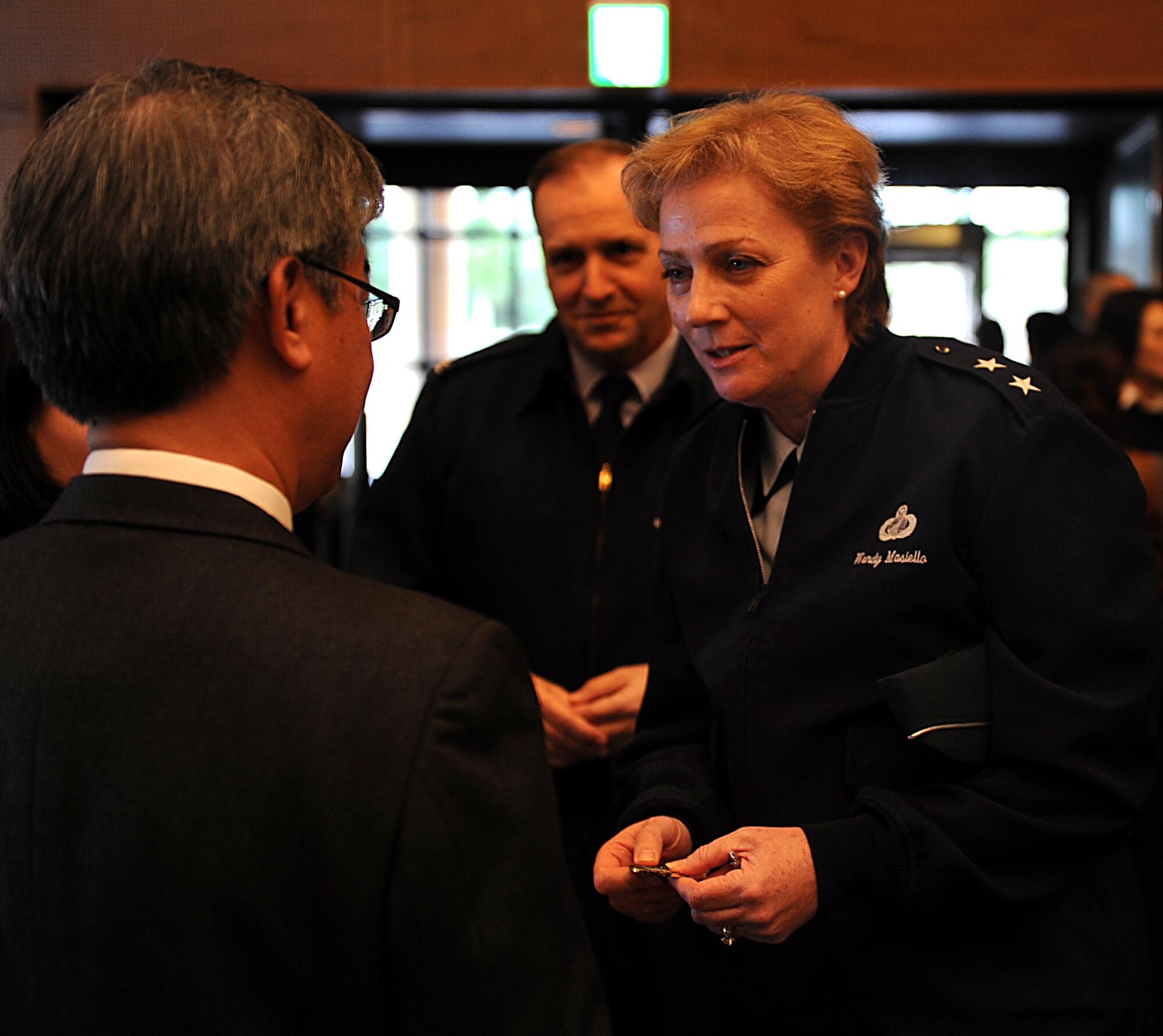 U.S. Air Force Maj. Gen. Wendy Masiello, deputy assistant secretary for contracting, Office of the Assistant Secretary of the Air Force for Acquisition, Washington, D.C.,  presents a coin to Eduardo Oyadomari, who helped put on the Okinawa First Vendor Showcase in Okinawa, Japan, Feb. 3, 2012. Maj. Gen. Masiello was visiting overseas contracting squadrons to recognize the great work that is often done in small communities with smaller dollars. (U.S. Air Force photo by Airman 1st Class Brooke P. Beers/Released)