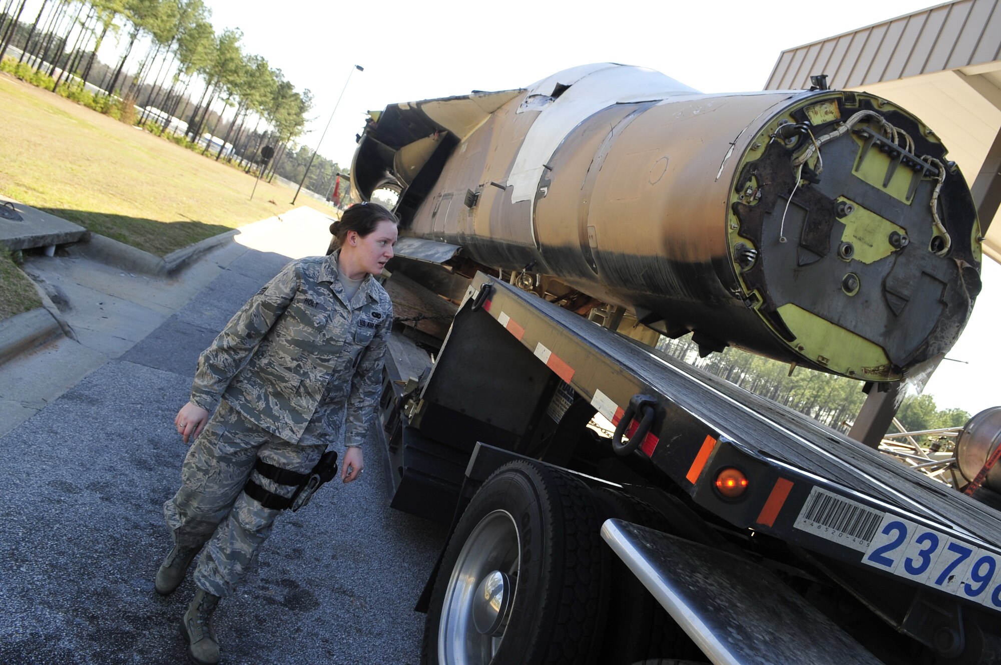 SHAW AIR FORCE BASE, S.C. - U. S. Air Force Senior Airman Angela Holt, a native of Wayne, N.J. and a member of the 20th Security Forces Squadron inspects a truck transporting an F-111E Aardvark that will be used as a static display while working at the security gate of Shaw AFB, S.C. on Feb. 2, 2012.  The Aardvark will be assembled over a four-month period and then there will be a dedication ceremony to welcome the aircraft back to the 20th Fighter Wing. (U.S.  Air Force photo/Master Sgt. Cohen A. Young)