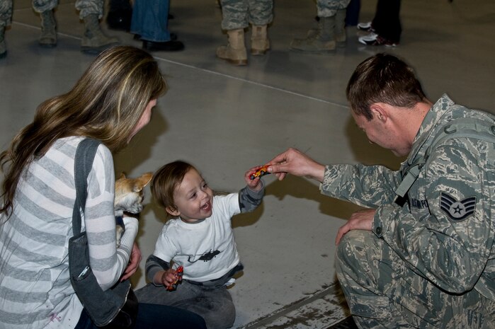 U.S. Air Force Staff Sgt. Brian Kraus, 763rd Rescue Maintenance Squadron member,  plays with his son during a homecoming celebration Feb. 8, 2012, inside the 763rd Rescue Maintenance Squadron hangar on Nellis Air Force Base, Nev.  The returning 71 Airmen, most of whom are assigned to either the 66th Rescue Squadron or the 763rd Rescue Maintenance Squadron, comprised the last Air Force rescue unit stationed in Iraq prior to the withdrawal of U.S. forces in December 2011. (U.S. Air Force photo by Airman 1st Class Daniel Hughes)