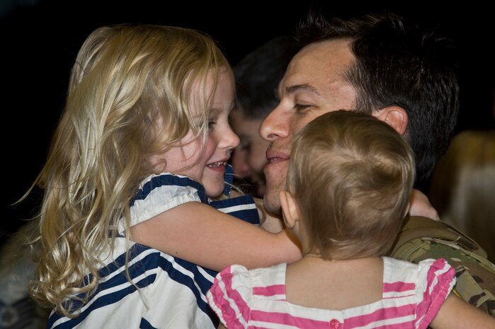 U.S. Air Force Capt. Benjamin Buchta, 66th Rescue Squadron flight commander,  embraces his daughters during a homecoming celebration Feb. 8, 2012, inside the 763rd Rescue Maintenance Squadron hangar on Nellis Air Force Base, Nev.  The returning 71 Airmen, most of whom are assigned to either the 66th Rescue Squadron or the 763rd Rescue Maintenance Squadron, comprised the last Air Force rescue unit stationed in Iraq prior to the withdrawal of U.S. forces in December 2011. (U.S. Air Force photo by Airman 1st Class Daniel Hughes)