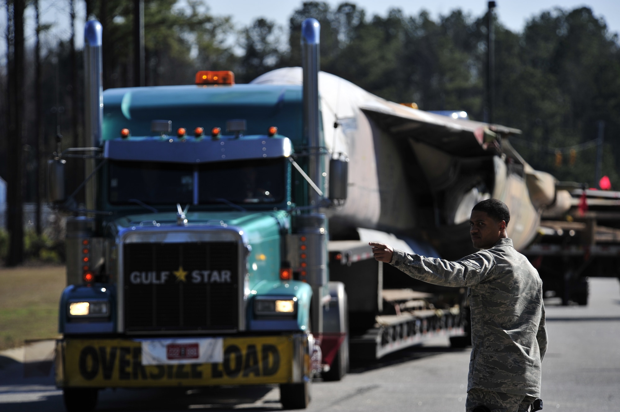SHAW AIR FORCE BASE, S.C. - U. S. Air Force Senior Airman Richard Townsend, native of Grand Rapids, Mich., and a member of the 20th Security Forces Squadron directs a truck transporting parts of an F-111E Aardvark that will be used as a static display while at Shaw AFB, S.C. on Feb. 2, 2012.  The Aardvark will be assembled over a four-month period and then there will be a dedication ceremony. (U.S.  Air Force photo/Master Sgt. Cohen A. Young)