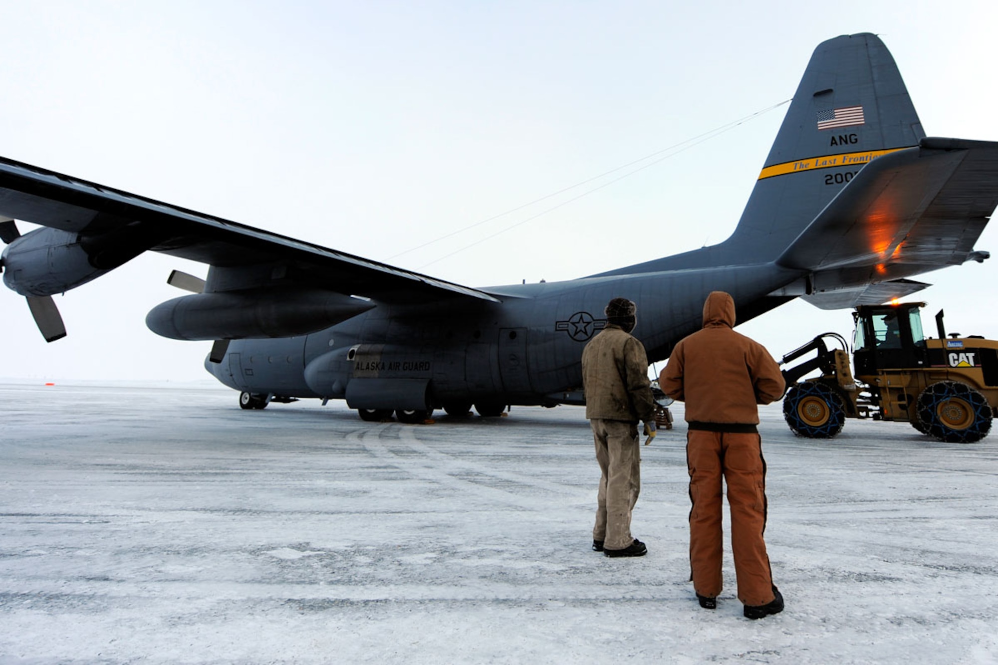 Tin City, Alaska, radar site employees look on as a C-130H Hercules is unloaded during a site mission performed by the 537th Airlift Squadron.  (U.S. Air Force photo/Tech Sgt. Brian Ferguson)