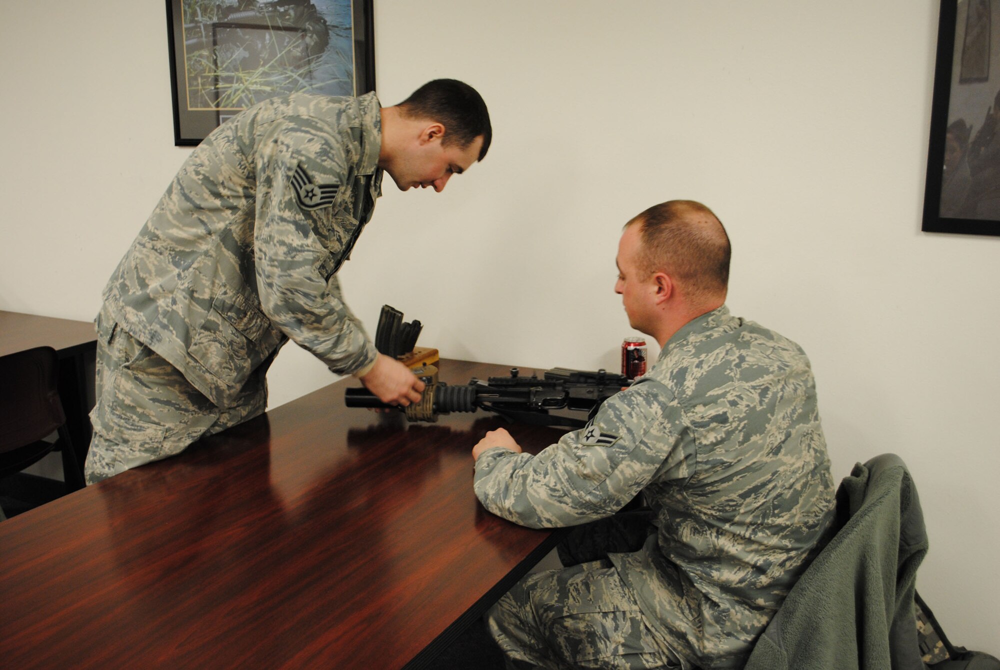 Staff Sgt. Scott Maciel, 341st Security Forces Squadron CATM instructor, explains the operation of an AN/PSQ-18 day/night M-203 sight to Airman 1st Class Phillip Warren, 741st Missile Security Forces Squadron member. (U.S. Air Force photo/Airman 1st Class Cortney Paxton)