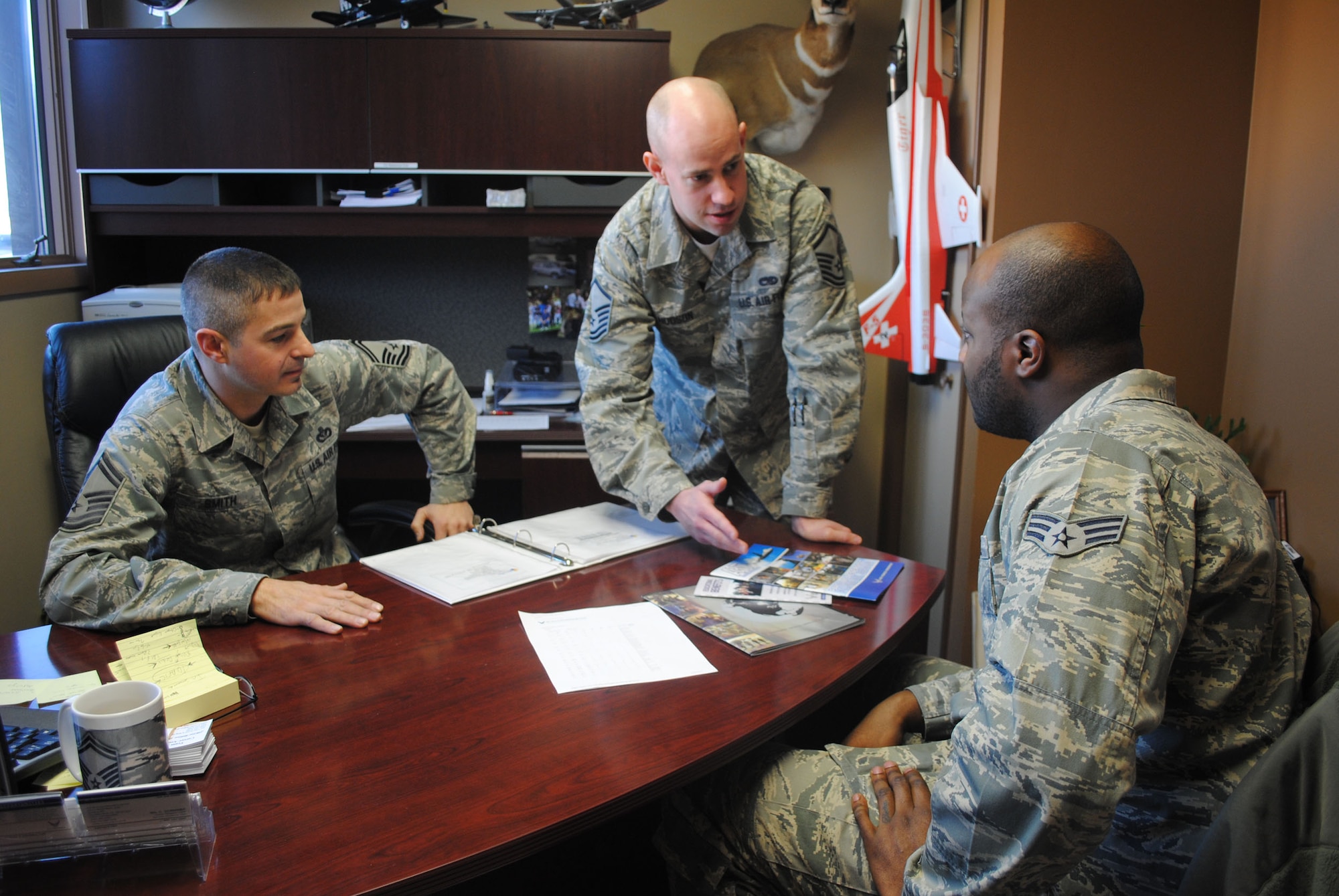Senior Master Sgt. William Smith, 341st Force Support Squadron career assistance advisor, and Master Sgt. Derek Hudson, 341st FSS in-service recruiter, explain various career choices to Senior Airman Reggie Manning, 341st Logistics Readiness Squadron. (U.S. Air Force photo/Airman 1st Class Katrina Heikkinen)