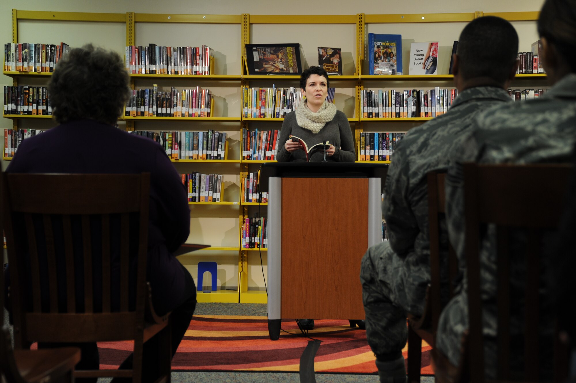 Jehanne Dubrow, author, recites poetry to an audience of Team Andrews service members and spouses at the Joint Base Andrews Library, Feb. 3 during their first Poetry and Pizza event. Dubrow read a compilation of poems from her latest collection “Stateside,” based on dealing with deployment as a military spouse. (U.S. Air Force photo/Senior Airman Bahja J. Jones) 