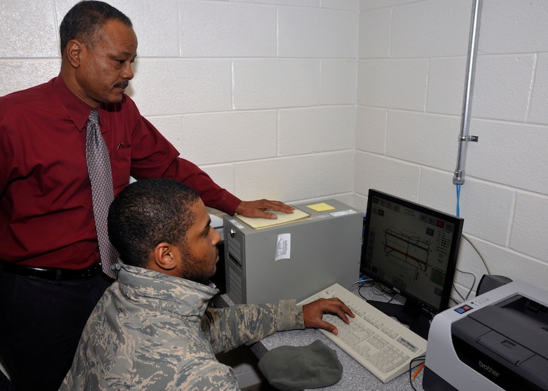 Airman 1st Class Steven Stroud, 11th Civil Engineer Squadron electrical systems apprentice, and Michael Butts, 11 CES electrical engineering technician, check Andrews airfield lighting displays using computer model configurations here, Feb. 8. (U.S. Air Force photo/Airman 1st Class Lindsey A. Beadle)