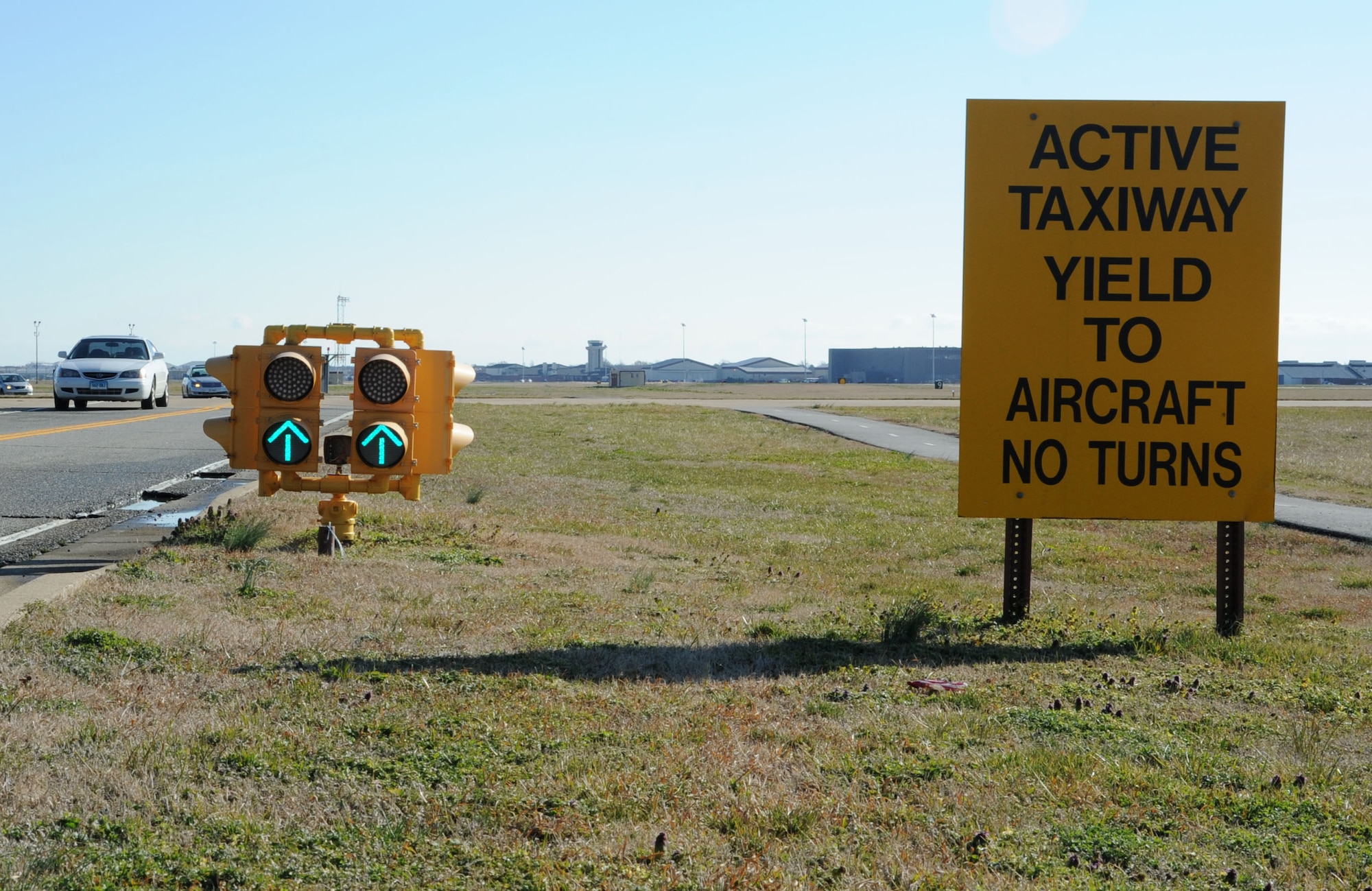 Drivers pass the airfield traffic signals on Lee Road on Langley Air Force Base Feb. 9. Drivers on base must yield to oncoming aircraft and/or flightline vehicles crossing Lee Road. (U.S. Air Force photo by Senior Airman John Strong/Released)
