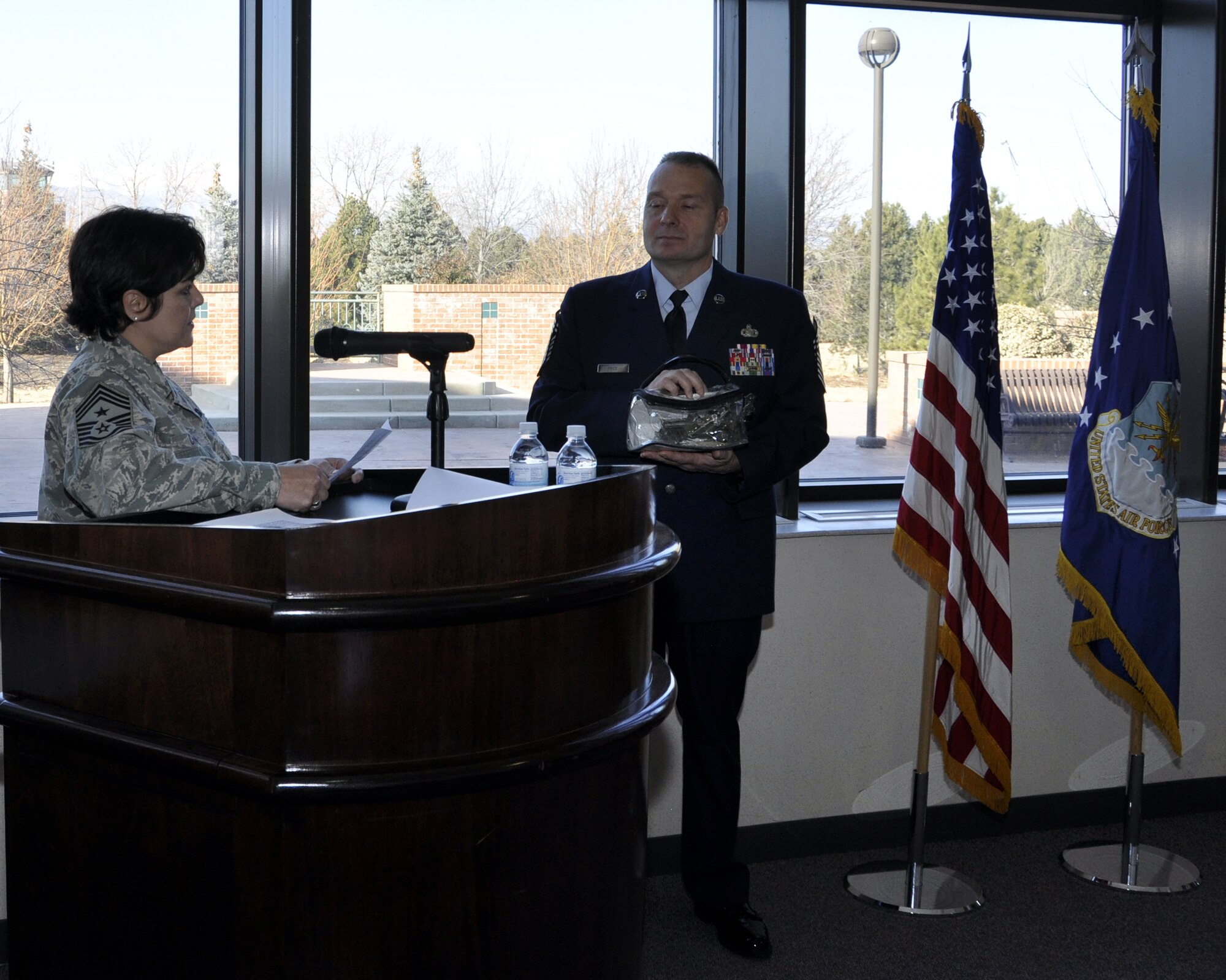 302nd Airlift Wing Command Chief Suzette Cherry reads instructions to newly promoted 302nd Security Forces Squadron Chief Ronald Price on the proper care of the Jeep. As the newest chief, Chief Price also becomes the Jeep Chief, and in following Air Force tradition as Jeep Chief, he is required to keep the Jeep in his possession at all times while in uniform. (U.S. Air Force photo/Tech. Sgt. Peter Dean)