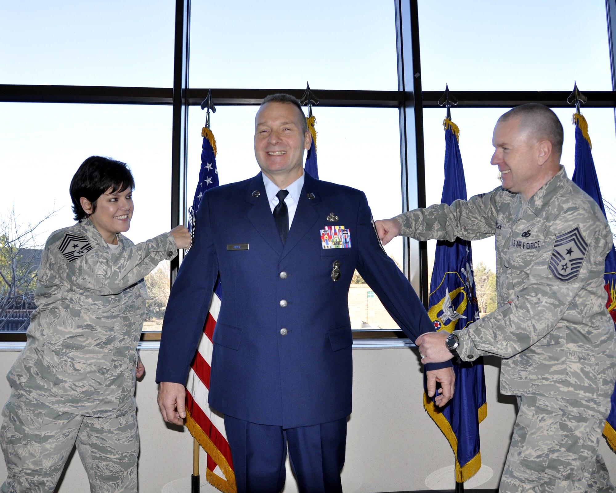 302nd Airlift Wing Command Chief Suzette Cherry on left along with the 310th Space Wing Command Chief Gary Brown, pin Senior Master Sgt. Ronald Price to chief master sergeant of the 302nd security forces squadron. Chief Price, a thirty year seasoned enlisted Airman, 19 years on active duty and 11 years with the 302nd, is now responsible for training, readiness, and ensuring members of the 302nd SFS are ready to respond  when called upon. (U.S. Air Force photo/Tech. Sgt. Peter Dean)