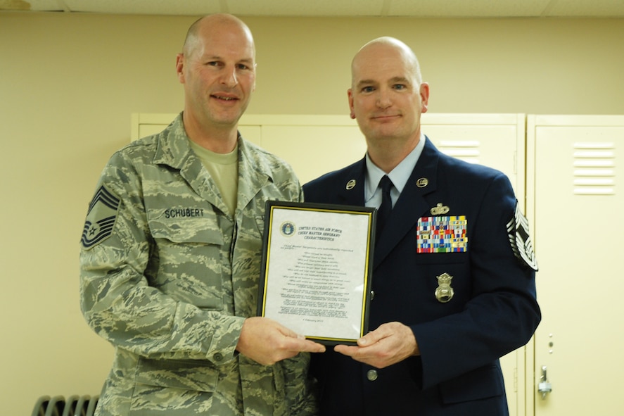 Chief Master Sgt. Mark A. Schubert, 94th Civil Engineering Squadron manager, reads the chief creed to Chief Master Sgt. DeMaine Milbach, 94 SFS manager, during a promotion and pin-on ceremony Feb. 4, at the base firing range. Milbach is succeeding Chief Master Sgt. Wendell Peacock, former 94 SFS manager and current 94th Airlift Wing Command Chief Master Sgt. (U.S. Air Force photo/Senior Airman Spencer Gallien)