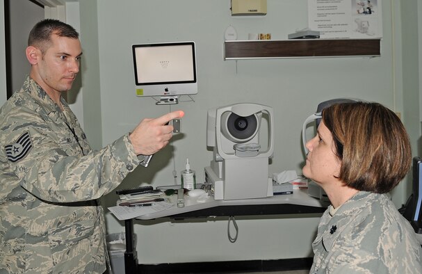 U.S. Air Force Tech. Sgt. Joel Ives checks U.S. Air Force Lt. Col. Holly Ellenberger’s eyes during a refractive eye surgery prescreening at the  4th Aerospace Medicine Squadron optometry clinic on Seymour Johnson Air Force Base, N.C., Feb. 7, 2012. Ives prescreens each patient to identify eye defects and supplies the provider who will perform the surgery with baseline information about the patient. Ives, 4th AMDS ophthalmic technician, hails from Argyle, N.Y. Ellenberger, 4th AMDS dental flight commander, hails from Bexley, Ohio. (U.S. Air Force photo/Senior Airman Gino Reyes/Released)