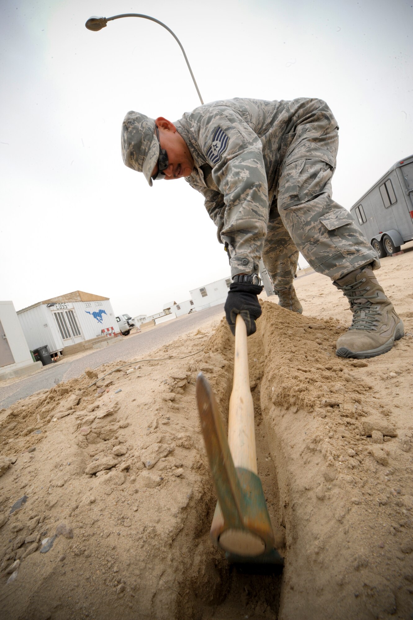 SOUTHWEST ASIA -- Tech. Sgt. Michael Araki, 332nd Expeditionary Communication Squadron infrastructure shop, uses a pickaxe to locate cables at an undisclosed location in Southwest Asia, Feb. 09, 2012. Araki dug carefully to ensure he didn’t disturb any cables. If a cable is disturbed, communication could be lost. Araki is deployed with the Hawaii Air National Guard, and is a native of Hilo, Hawaii. (U.S. Air Force photo by Staff Sgt. Joshua J. Garcia/Released)