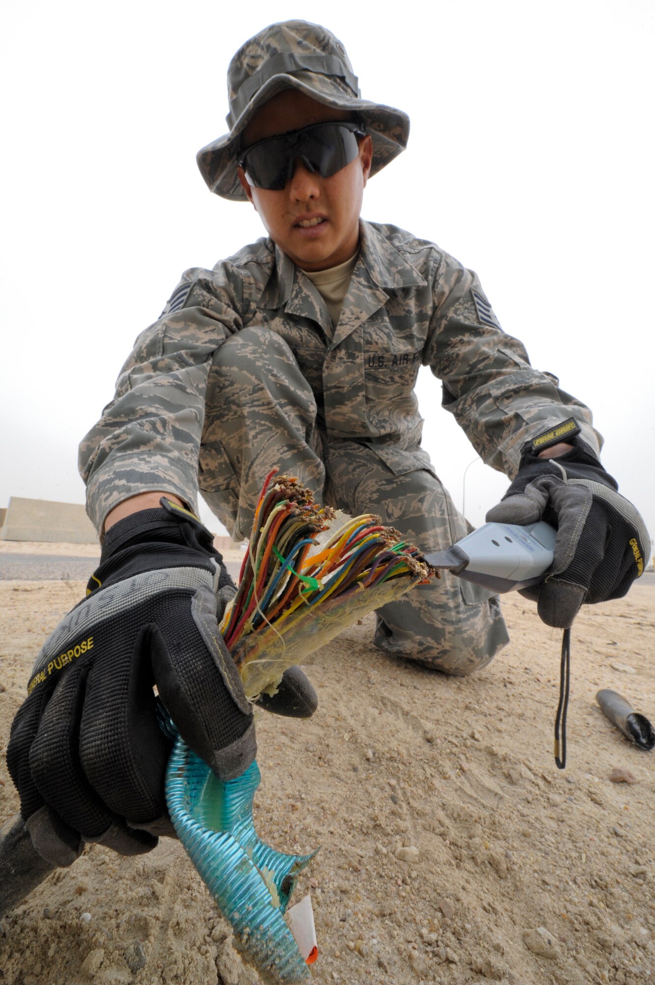 SOUTHWEST ASIA -- Staff Sgt. Kyle Otsuka, 332nd Expeditionary Communication Squadron infrastructure shop checks to see if a cable is operable at an undisclosed location in Southwest Asia, Feb. 9, 2012. The infrastructure shop is in charge of locating and disposing of inoperable cables on the base. Otsuka is deployed with the Hawaii Air National Guard and is a native to Hilo, Hawaii. (U.S. Air Force photo by Staff Sgt. Joshua J. Garcia/Released)