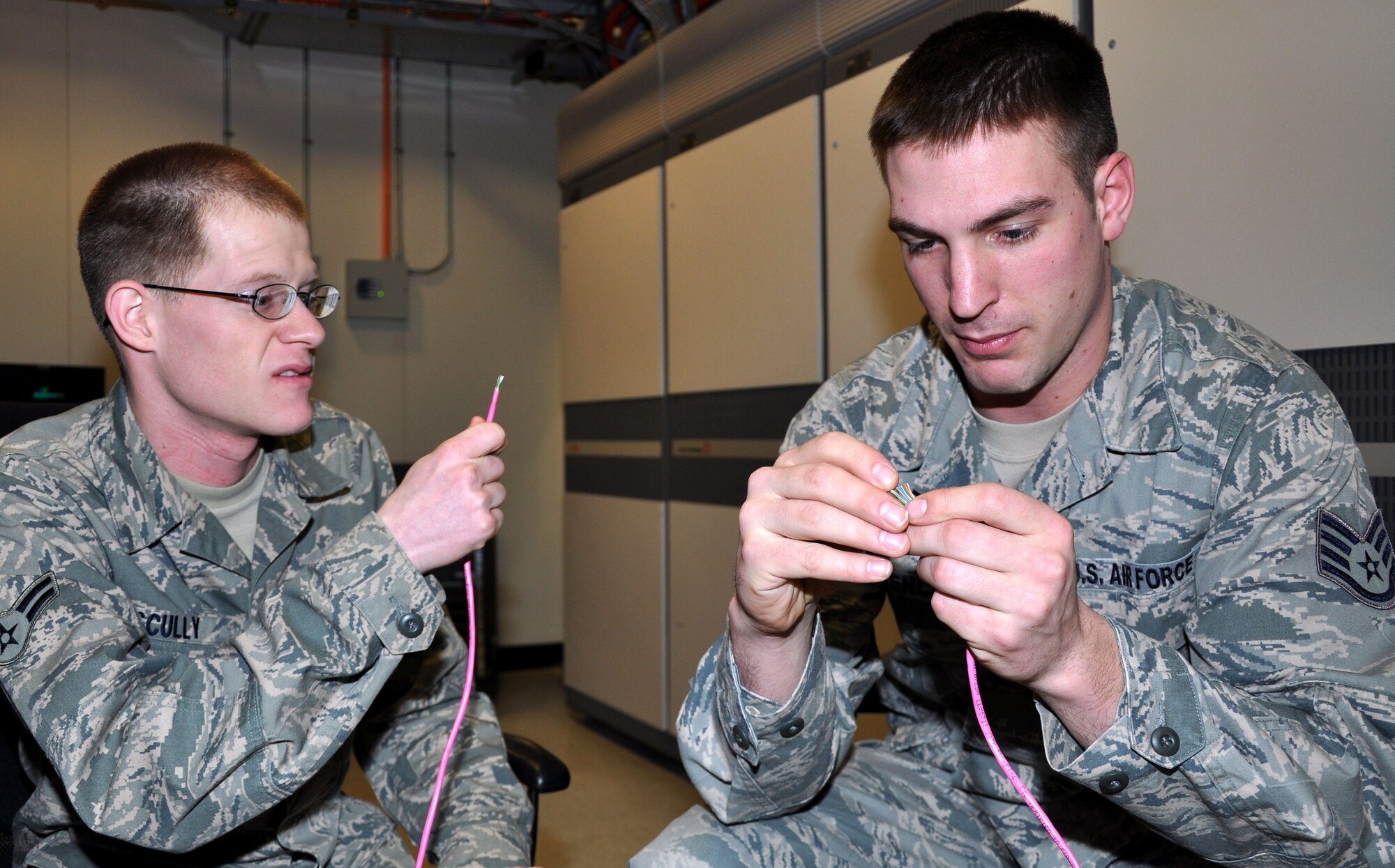 319th Communications Squadron Cyber transport technicians Staff Sgt. Timothy Stencil (right) and AIrman 1st Class Christian Scully (left) terminate Category 5 ethernet cables on Grand Forks Air Force Base, N.D., Feb. 2, 2012. Stencil is Scully's NCO and was named Warrior of the Week from Feb. 9 through 16. (U.S. Air Force photo/Airman 1st Class Derek VanHorn)