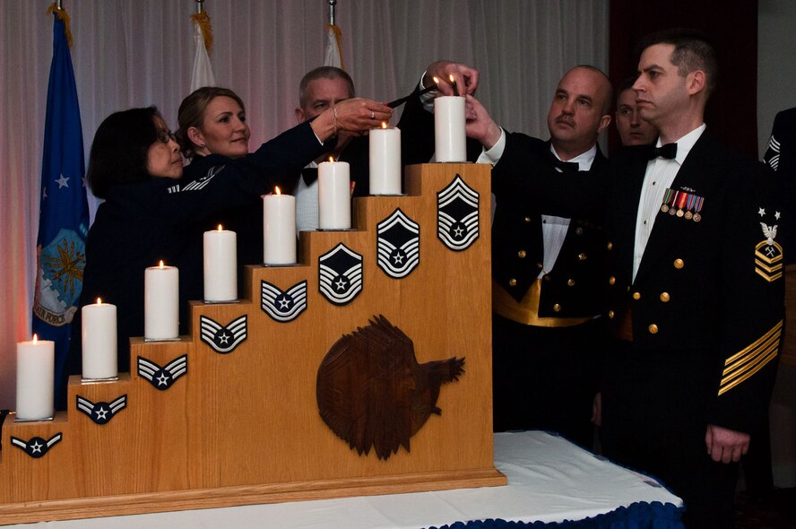 HANSCOM AIR FORCE BASE, Mass. – (from left to right) Chief Master Sgt. Lorna De La Cruz, Senior Master Sgt. Kathleen M. McCool, Master Chief Petty Officer Steve Hargis, Master Chief Petty Officer David C. Kroll and Master Chief Petty Officer Jamey Spurgeon light the top candle, signifying they have obtained the highest enlisted rank in the armed forces, during the Joint Service E-9 Recognition Ceremony at the Minuteman Commons on Feb. 3. Hosted by the 66th Air Base Group and the Hanscom Chief's Group, the ceremony recognized two members of the Air Force and three members of the Coast Guard. (U.S. Air Force photo by Rick Berry)