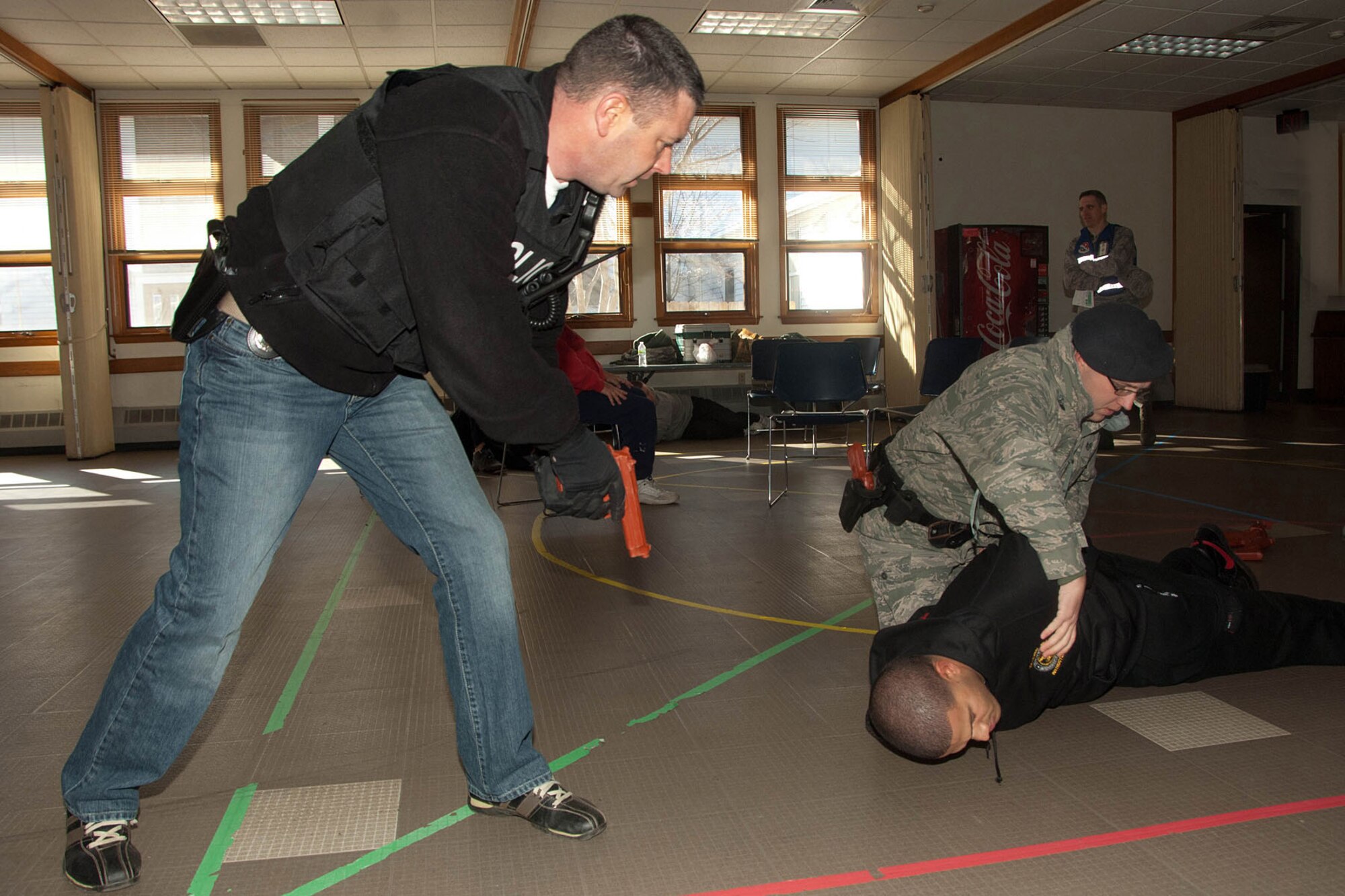 HANSCOM AIR FORCE BASE, Mass. - (from left to right) William Boyden, superintendant of investigations, and Staff Sgt. Richard Crotty, military working dog handler, “apprehend” Staff Sgt. Scott Roy, acting as a shooter, during an exercise at the base chapel Feb. 3. Base readiness exercises are conducted periodically to maintain readiness. (U.S. Air Force photo by Linda LaBonte Britt)
