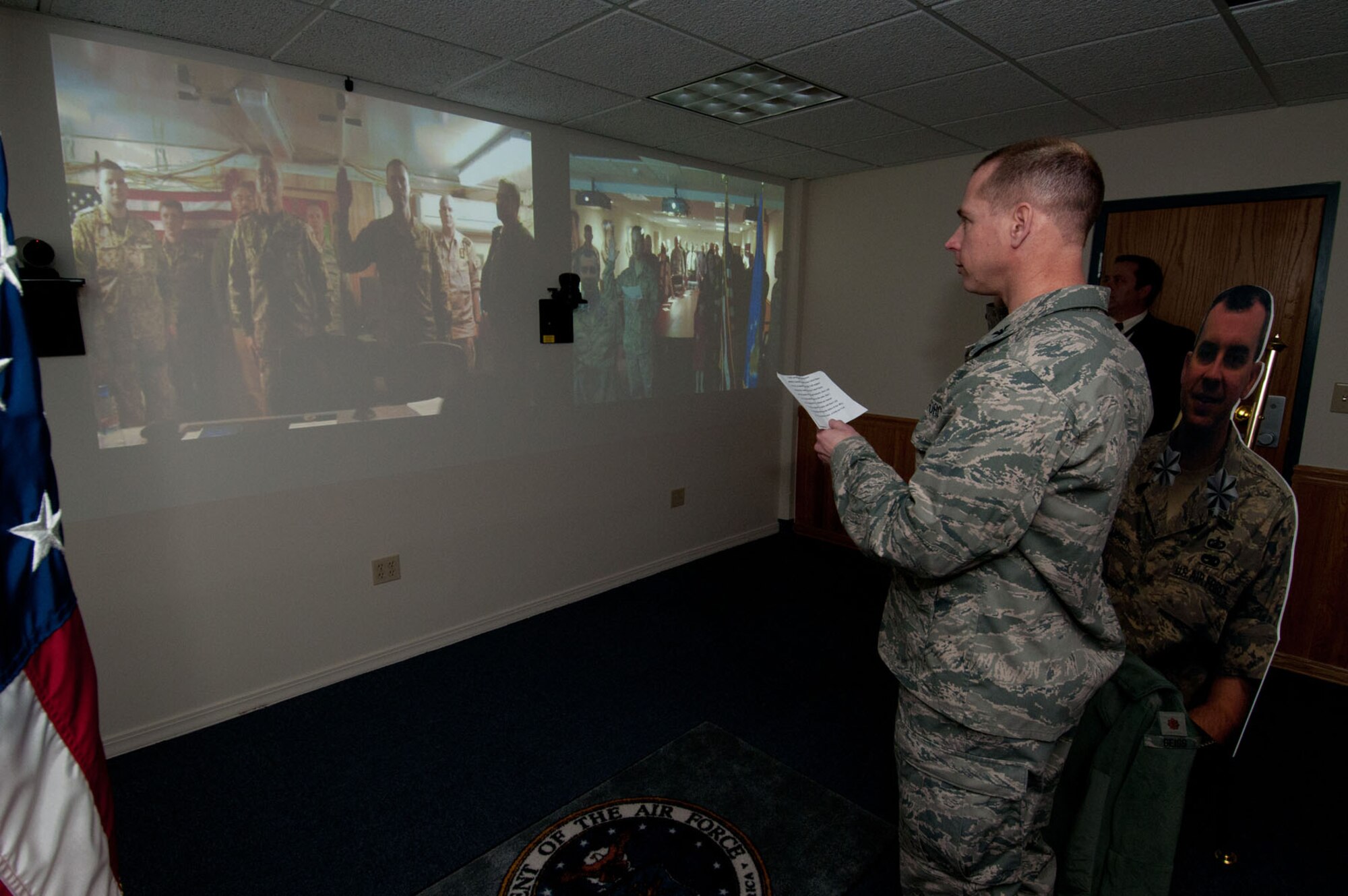HANSCOM AIR FORCE BASE, Mass. – Col. David Hiltz, Aerial Ground Surveillance Division chief, administers an oath to newly promoted Lt. Col. Chris Lardner, Next Generation Systems Branch, via video teleconference Jan. 5 as family, friends and co-workers watch. Lardner is deployed to Afghanistan along with coalition partners. A German colonel pinned on his new rank. (U.S. Air Force photo by Rick Berry)