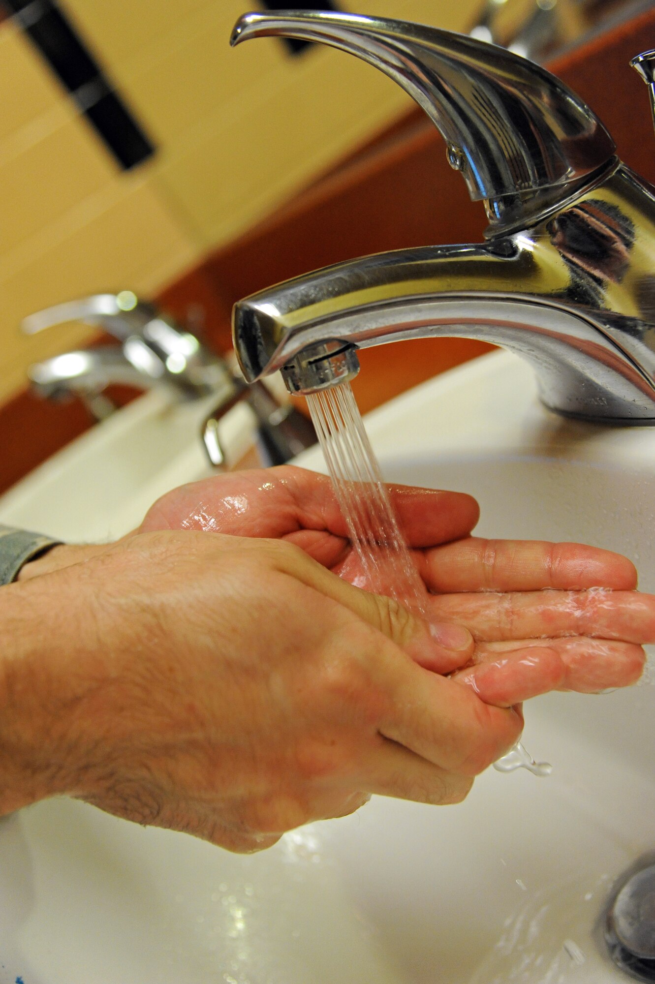 LAUGHLIN AIR FORCE BASE, Texas – An Airman washes his hands here Feb. 9 using the newly updated faucets. Laughlin’s 47th Civil Engineer Squadron initiated a project to change faucets and light bulbs to reduce energy and water consumption. The project is estimated to save $75,000 annually. (U.S. Air Force photo/Senior Airman Scott Saldukas)