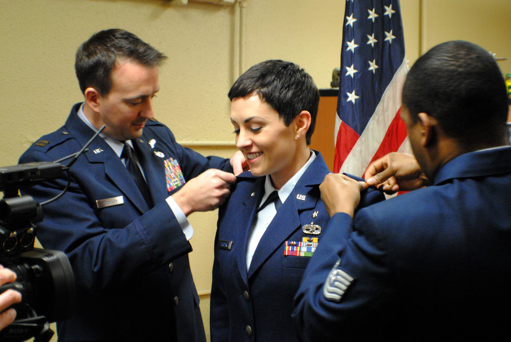 Capt. Timothy Dremann (left), Air Force ROTC Detachment 610 recruiting flight commander and Tech. Sgt. Robert Carter (right), AF ROTC Det. 610 NCO in charge pin gold bars on the shoulders of former Staff Sgt. Donna Tluczek, who became a medical officer in the Air Force during a commissioning ceremony, Feb. 2, 2012, at AF ROTC Det. 610 headquarters inside the University of North Dakota Armory. Tluczek passed North Dakota’s state boards test for nursing, solidifying both her official status as a BSN-registered nurse and commission as a second lieutenant in the United States Air Force Nurse Corps. (U.S. Air Force photo/Senior Airman Luis Loza Gutierrez)