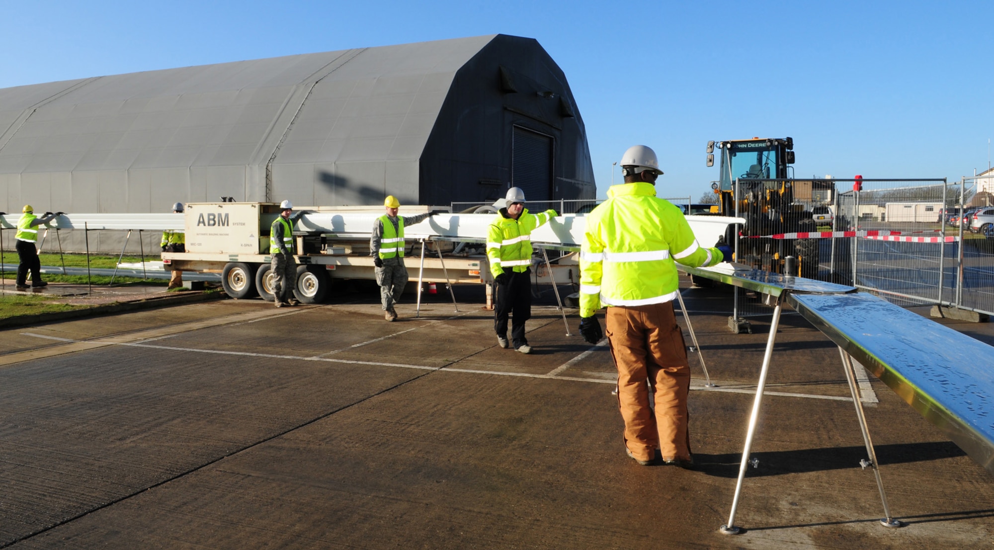 RAF MILDENHALL, England -- A steel panel is passed through a curve-former machine after first being transformed from a flat piece of steel sheet into a shaped panel Jan. 27, 2012 on the south side of base. Active duty members, along with one German national, from the 435th Construction and Training Squadron Military Construction Flight, from a geographically-separated unit near Ramstein Air Base, Germany, arrived here Jan. 9, and are scheduled to be at RAF Mildenhall for one month, building a new K-Span structure which will be used for equipment storage. (U.S. Air Force photo/Karen Abeyasekere)