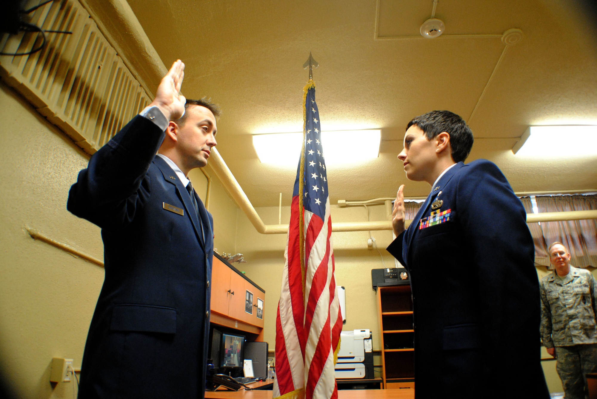 Capt. Timothy Dremann (left), Air Force ROTC Detachment 610 recruiting flight commander administers the Oath of Office to former Staff Sgt. Donna Tluczek (right), who became a medical officer in the Air Force during a commissioning ceremony, Feb. 2, 2012, at AF ROTC Det. 610 headquarters inside the University of North Dakota Armory. Prior to commissioning as a second lieutenant in the United States Air Force Nurse Corps, Tluczek was stationed as an enlisted member at Grand Forks Air Force Base, N.D., for three years, and served as a radar maintenance and electronics specialist. (U.S. Air Force photo/Senior Airman Luis Loza Gutierrez)