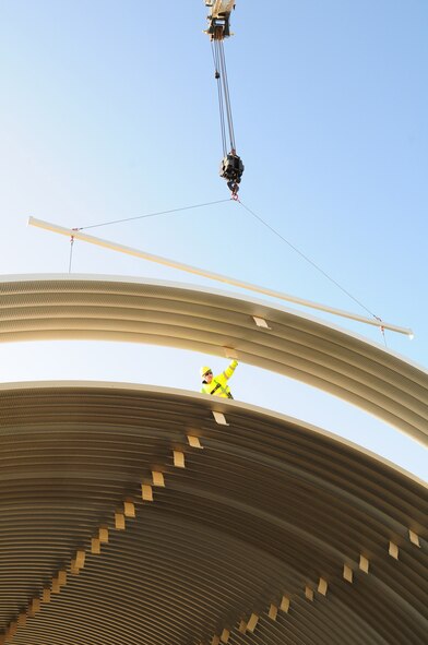 RAF MILDENHALL, England -- Tech. Sgt. Thomas Riggsbee, 435th Military Construction Flight, 435th Construction and Training Squadron, near Ramstein Air Base, Germany, helps raise a pick into place on a K-Span structure on the south side of base Jan. 27, 2012. The construction team from Germany – consisting of 14 U.S. Air Force active duty members and one German national -- are based at a geographically-separated unit near Ramstein AB, and have been at RAF Mildenhall since Jan. 9, 2012, putting together the steel structure completely from scratch. Four military members from the 100th Civil Engineer Squadron and two from 48th Civil Engineer Squadron have also assisted in the construction and received beneficial training from the 435th MCF. (U.S. Air Force photo/Karen Abeyasekere)