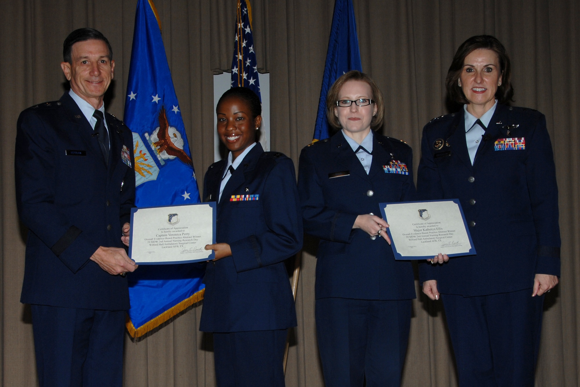 59th Medical Wing Commander Maj. Gen. Byron Hepburn (left) and Maj. Gen. Kimberly Siniscalchi (right) present awards to Capt. Veronica Perry and Maj. Katheryn Ellis for their winning poster Jan. 27, 2012, during the 59th MDW second annual Nursing Research Day at Wilford Hall Ambulatory Surgical Center, Lackland Air Force Base, Texas. Air Force nurses Perry (center left) and Ellis illustrated how two pediatric clinical nurse specialists sought to move from a tradition-based to an evidenced-based practice. Siniscalchi is assistant Air Force Surgeon General, Medical Force Development, and assistant Air Force Surgeon General, Nursing Services. (U.S. Air Force photo by Harold China)