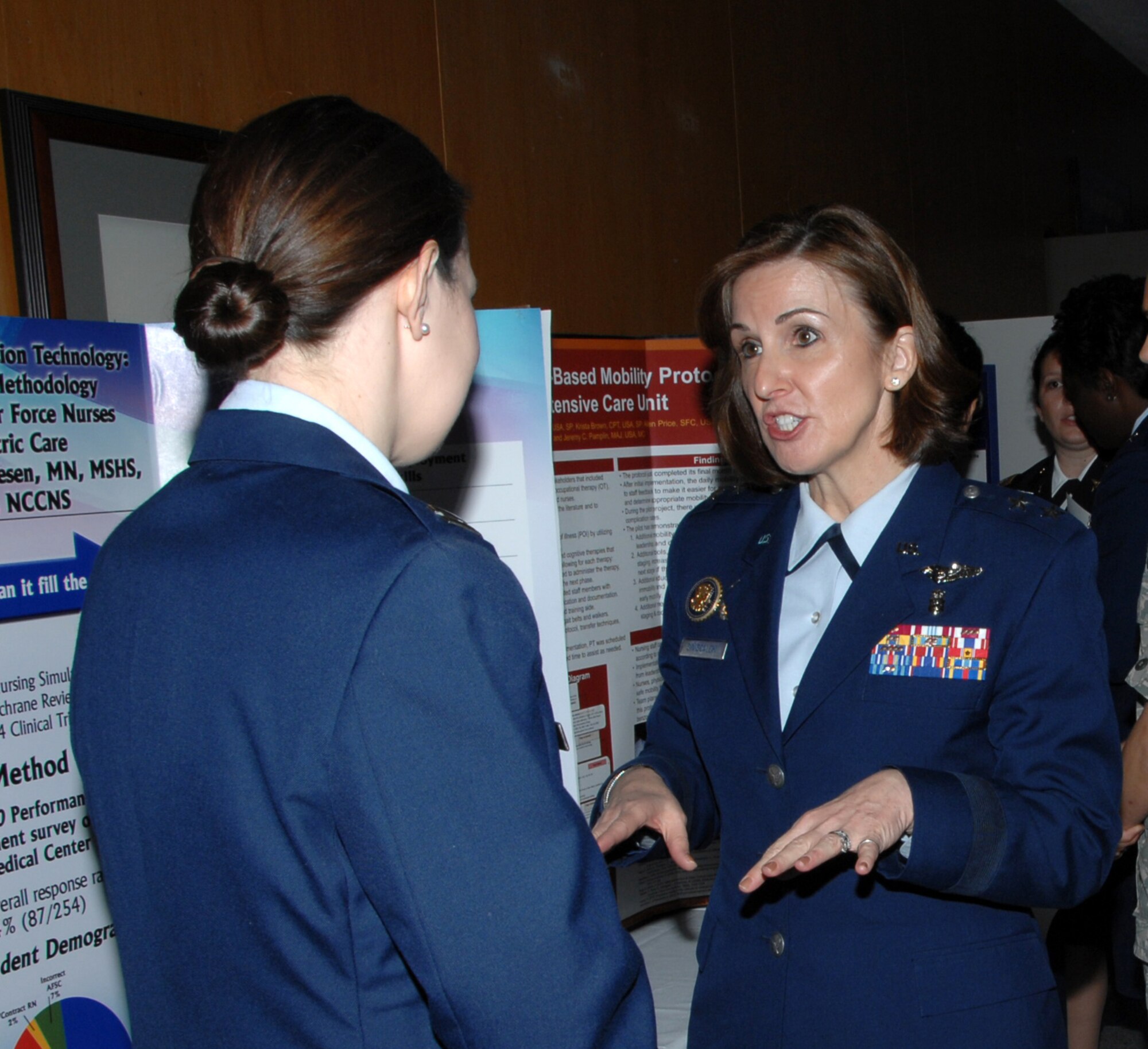 Maj. Gen. Kimberly Siniscalchi (center) speaks with Capt. Stacy Friesen about her poster presentation during the 59th Medical Wing second annual Nursing Research Day Jan. 27, 2012, at Wilford Hall Ambulatory Surgical Center, Lackland Air Force Base, Texas. Siniscalchi is assistant Air Force Surgeon General, Medical Force Development, and assistant Air Force Surgeon General, Nursing Services. Friesen is a registered nurse, 59th Medical Inpatient Squadron. (U.S. Air Force photo by Harold China)