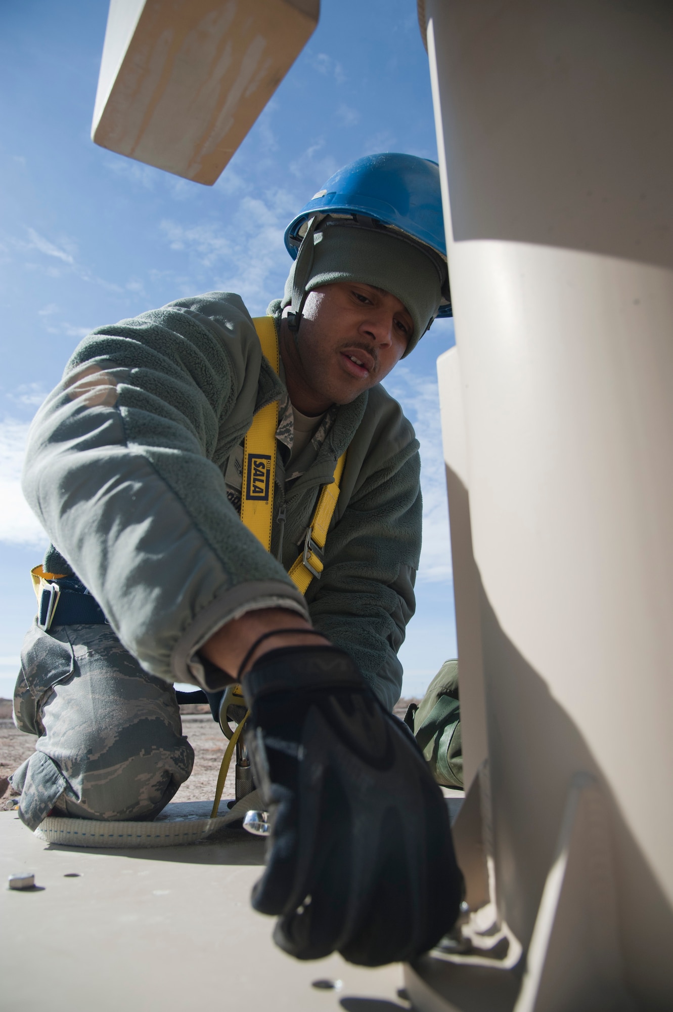 HOLLOMAN AIR FORCE BASE, N.M. -- U.S. Air Force Senior Airman Mark Murray, 849th Aircraft Maintenace Squadron remotely piloted aircraft communications technician, unfastens a bolt connecting a ground data terminal unit to a platform, Feb. 7. After unbolting the GDT from its shipping platform, it’s lifted by a crane, and installed on a tower to reduce potential line-of-sight deficiencies for RPAs. (U.S. Air Force photo by Airman 1st Class Siuta B. Ika/ Released)