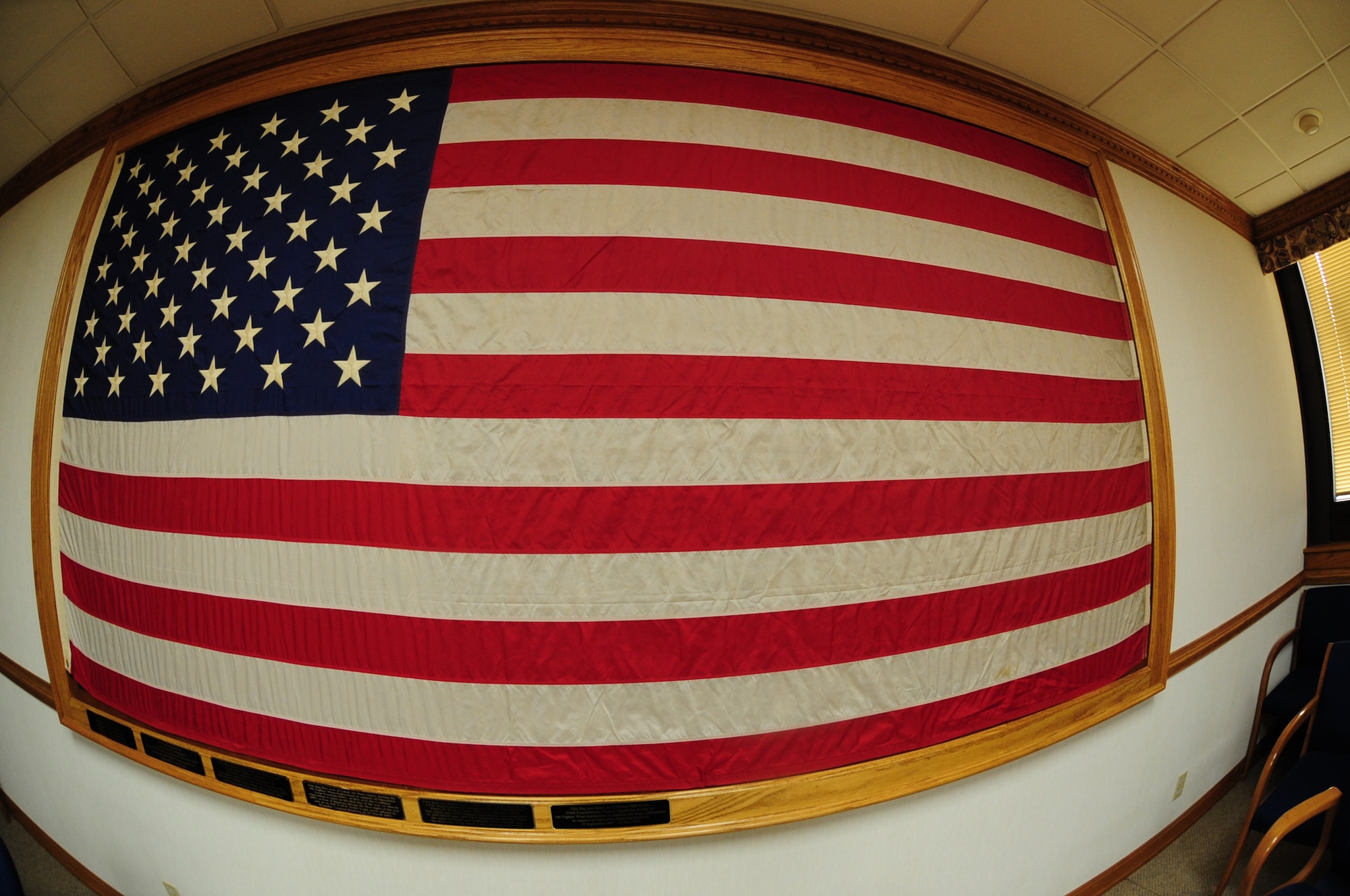 An American flag hangs in the wing conference room on Seymour Johnson Air Force Base, N.C., Feb. 7, 2012. This flag has been flown in theater by the 335th and 336th Fighter Squadrons for more than 20 years. It has represented the United States and the 4th Fighter Wing in Operations Desert Shield, Desert Storm, Noble Eagle, Southern Watch, Enduring Freedom, Anaconda, Iraqi Freedom and Enduring Freedom. (U.S. Air Force photo/Airman 1st Class Mariah Tolbert/ Released)