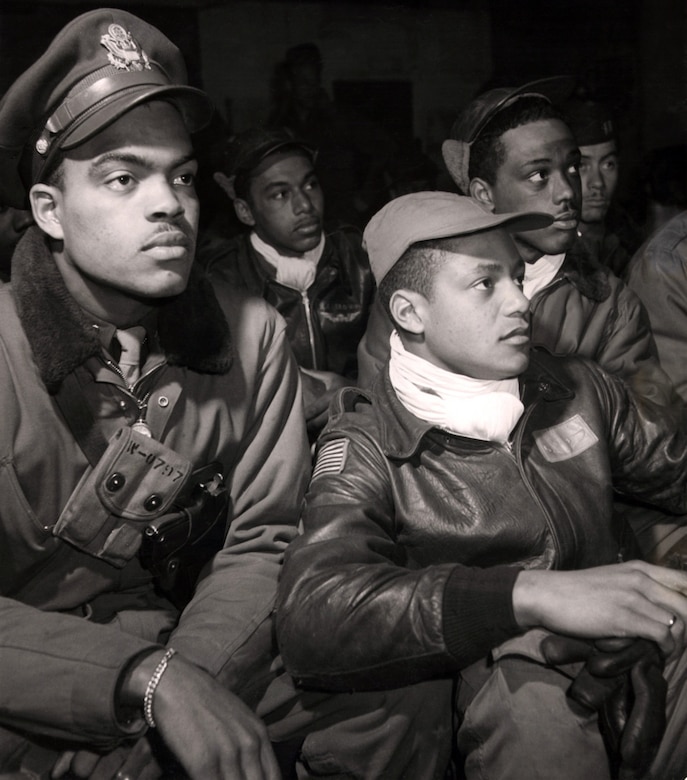 Airmen of the 332nd, from left to right: Robert W. Williams, William H. Holloman, Ronald W. Reeves, Christopher W. Newman and Walter M. Downs listen to a briefing in March 1945.  Photo by Toni Frissell, Library of Congress.