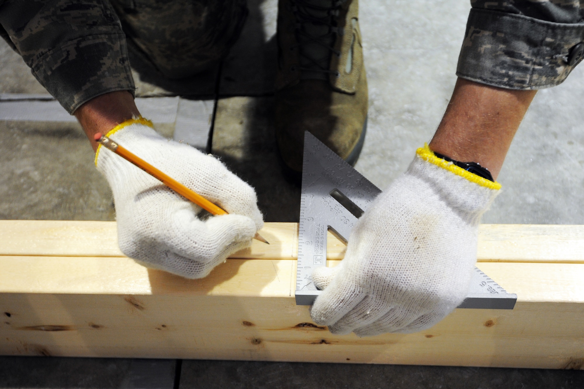 MISAWA AIR BASE, Japan -- Airman 1st Class Derek Wagner, 35th Civil Engineer Squadron structural apprentice, marks lumber in Building 1366 here, Feb. 8. The lumber will be cut and used for building renovations on the new location for a stray animal temporary care facility. PAWS is a private organization here that will operate the new facility. (U.S. Air Force photo/Airman 1st Class Kia Atkins)