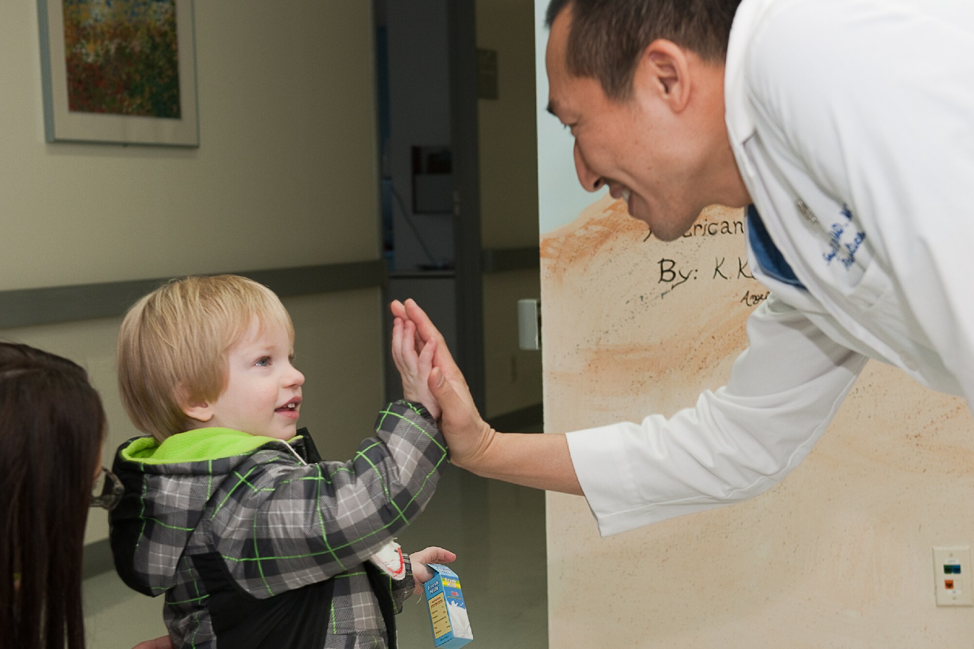 YOKOTA AIR BASE, Japan -- Lt. Col. Song Rhim, 374th Dental Squadron doctor of dental medicine, and Adam Jones, 3, high-five after a children dental health class at Yokota Air Base, Japan, Feb. 9, 2012. In celebration of National Children's Dental Health Month, which is the month of February, members from the 374th DS invite children for dental health class to increase their awareness of good oral health habits. (U.S. Air Force photo/Osakabe Yasuo) 