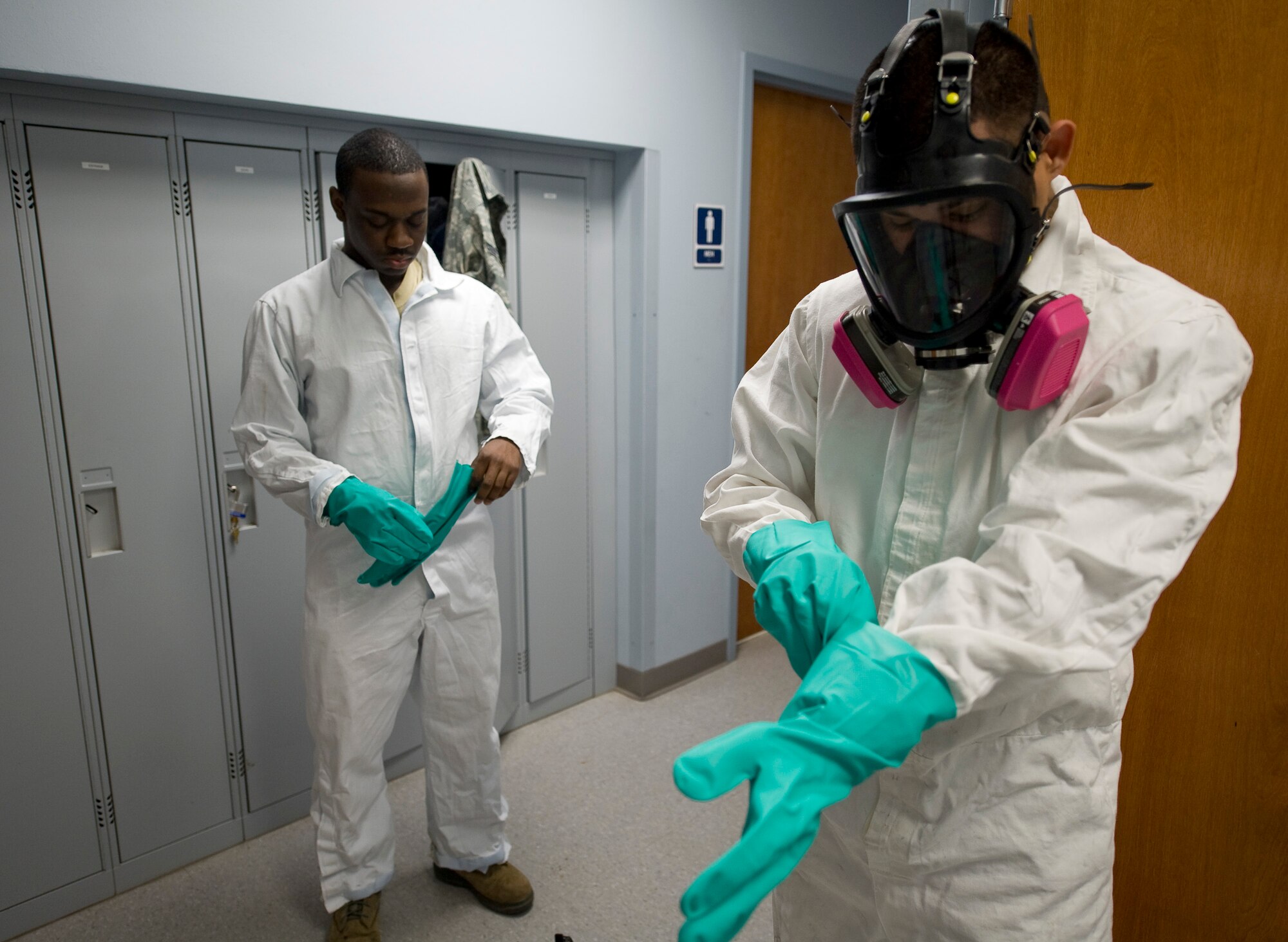 Senior Airman Thomas Davis and Senior Airman Jose Pinzon-Galarza, 2nd Civil Engineer Squadron Pest Management Flight, don protective gear on Barksdale Air Force Base, La., Feb. 9. The equipment is meant to protect the Airmen from potentially dangerous chemicals while handling pesticides.  (U.S. Air Force photo/Senior Airman Chad Warren)(RELEASED)