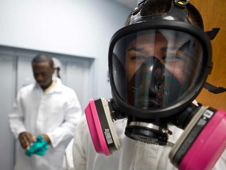 Senior Airman Thomas Davis and Senior Airman Jose Pinzon-Galarza, 2nd Civil Engineer Squadron Pest Management Flight, don protective gear on Barksdale Air Force Base, La., Feb. 9. The equipment is meant to protect the Airmen from potentially dangerous chemicals while handling pesticides.  (U.S. Air Force photo/Senior Airman Chad Warren)(RELEASED)
