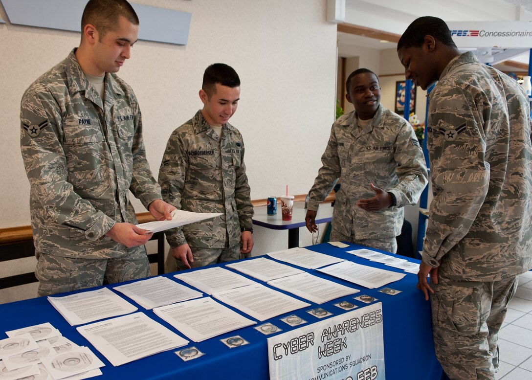 Members of the 28th Communications Squadron hand out information and virus protection software to Airmen during cyber awareness week on Ellsworth Air Force Base, S.D., Feb. 8, 2012. The Airmen educated Ellsworth personnel on the importance of cyber awareness, addressing web-based security, preventing communication security incidents, and teaching adversarial tactics to cyber attacks during the week-long event. (U.S. Air Force photo by Airman Alystria Maurer/Released)