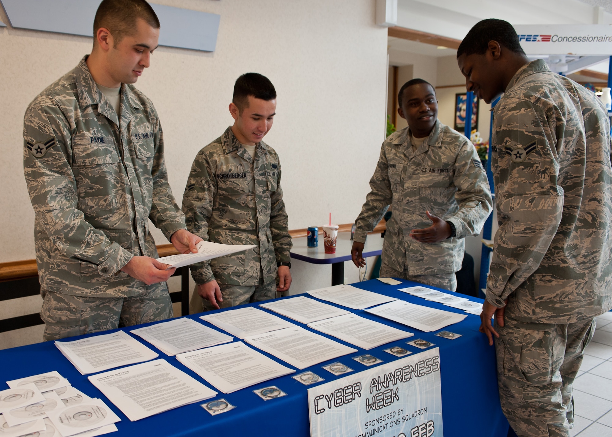 Members of the 28th Communications Squadron hand out information and virus protection software to Airmen during cyber awareness week on Ellsworth Air Force Base, S.D., Feb. 8, 2012. The Airmen educated Ellsworth personnel on the importance of cyber awareness, addressing web-based security, preventing communication security incidents, and teaching adversarial tactics to cyber attacks during the week-long event. (U.S. Air Force photo by Airman Alystria Maurer/Released)