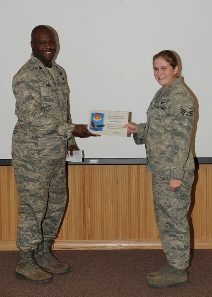 Lt. Col. Keith Green, 317th Airlift Group, presents Senior Airman Kassandra Cline, 317 AG, with the February 317 AG superior performer award, Feb. 9,  2012, at Dyess Air Force Base, Texas. Every month each group selects one person or team who has shown superior performance to be recognized in front of wing leadership. (U.S. Air Force photo by Airman 1st Class Peter Thompson/Released) 